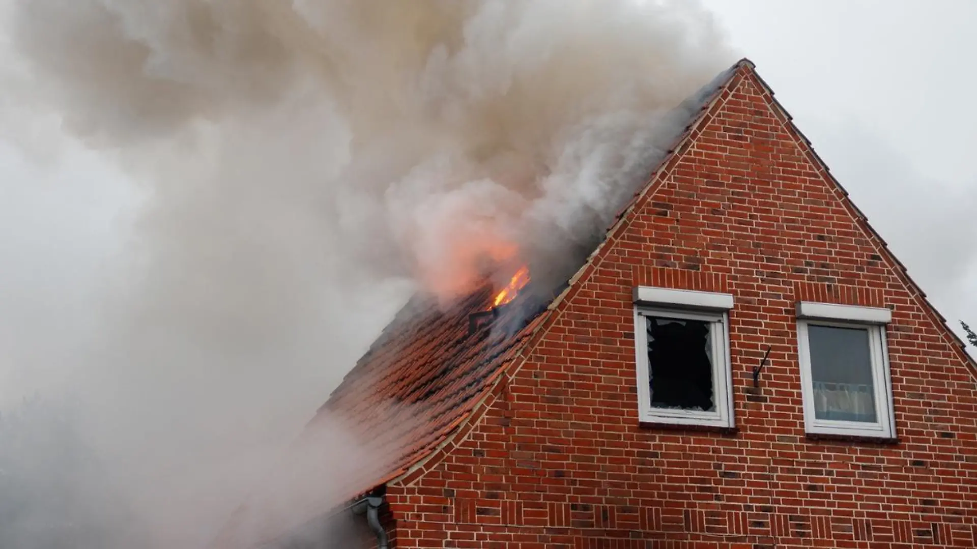 Das Feuer breitete sich schnell im Erd- und im Dachgeschoss aus, Fensterscheiben und Glasbausteine zerbarsten. 

Quelle: Feuerwehr/Florian Schulz