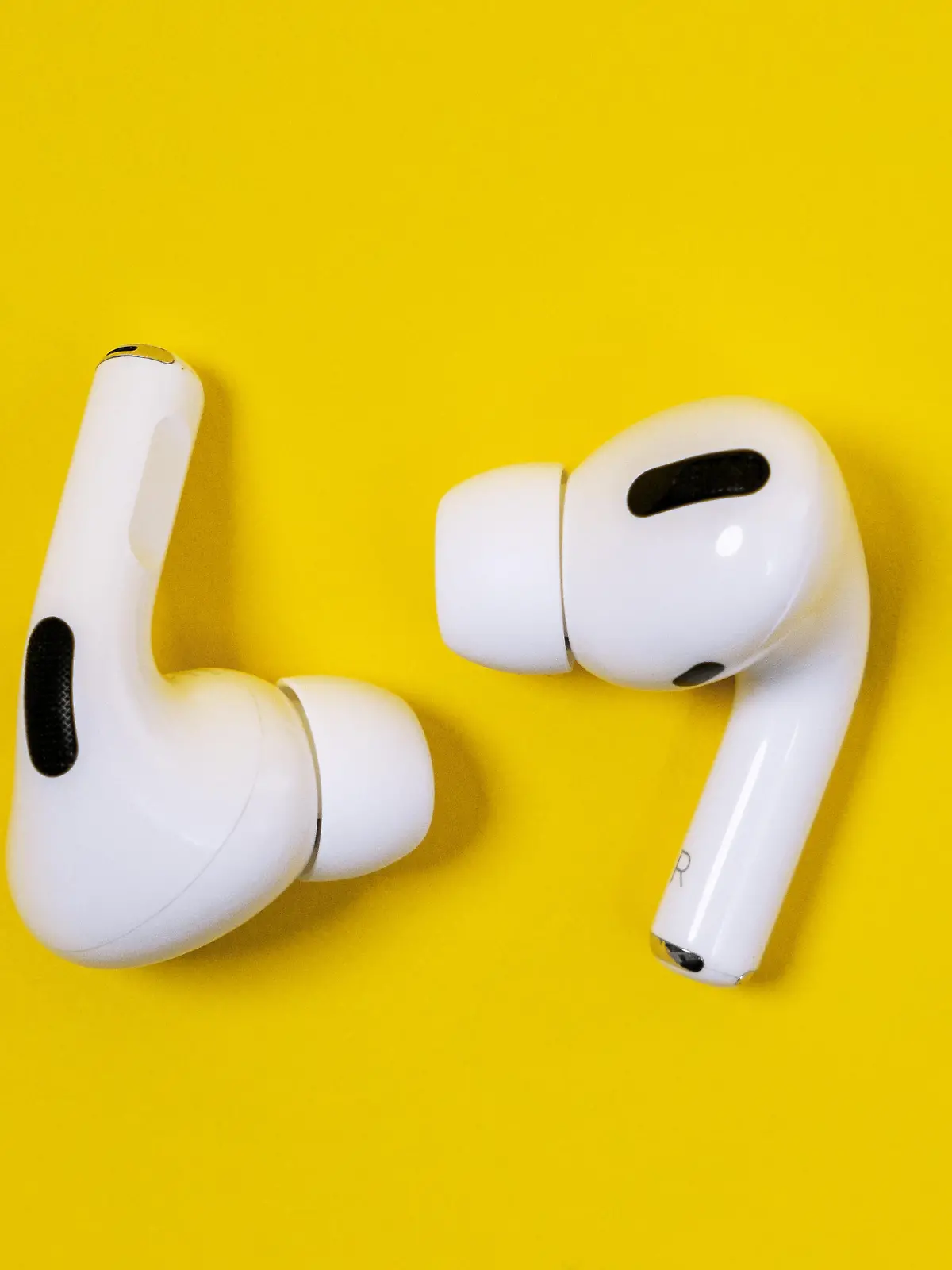 Rostov, Russia - July 06, 2020: Apple AirPods Pro on a yellow background. Silent wireless headphones close up.