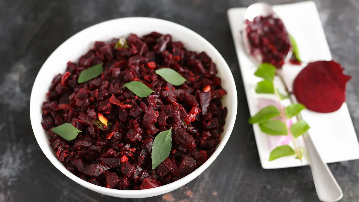 Beetroot curry stir fry, Kerala style organic beetroot Thoran curry recipe on blue white background Tamil Nadu South India. Vegetarian salad from boiled beet. Top view of Indian food veg side dish.