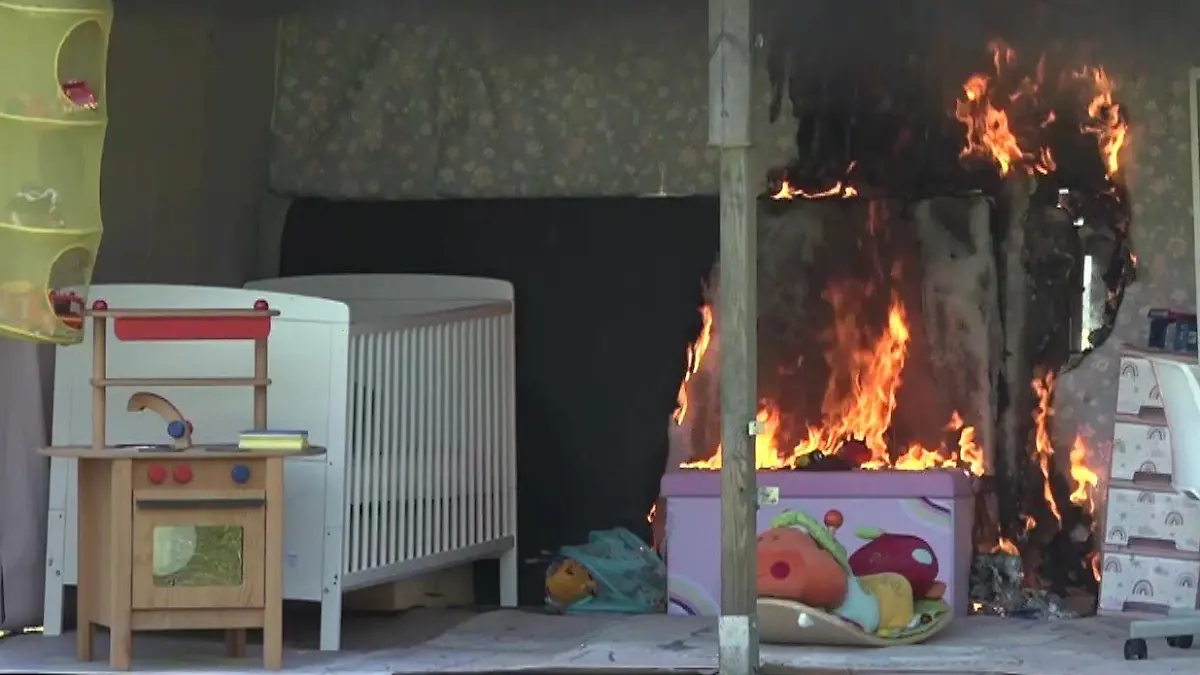 Ortsbrandmeister Janßen startet das Feuer mit einem brennenden Blattpapier.