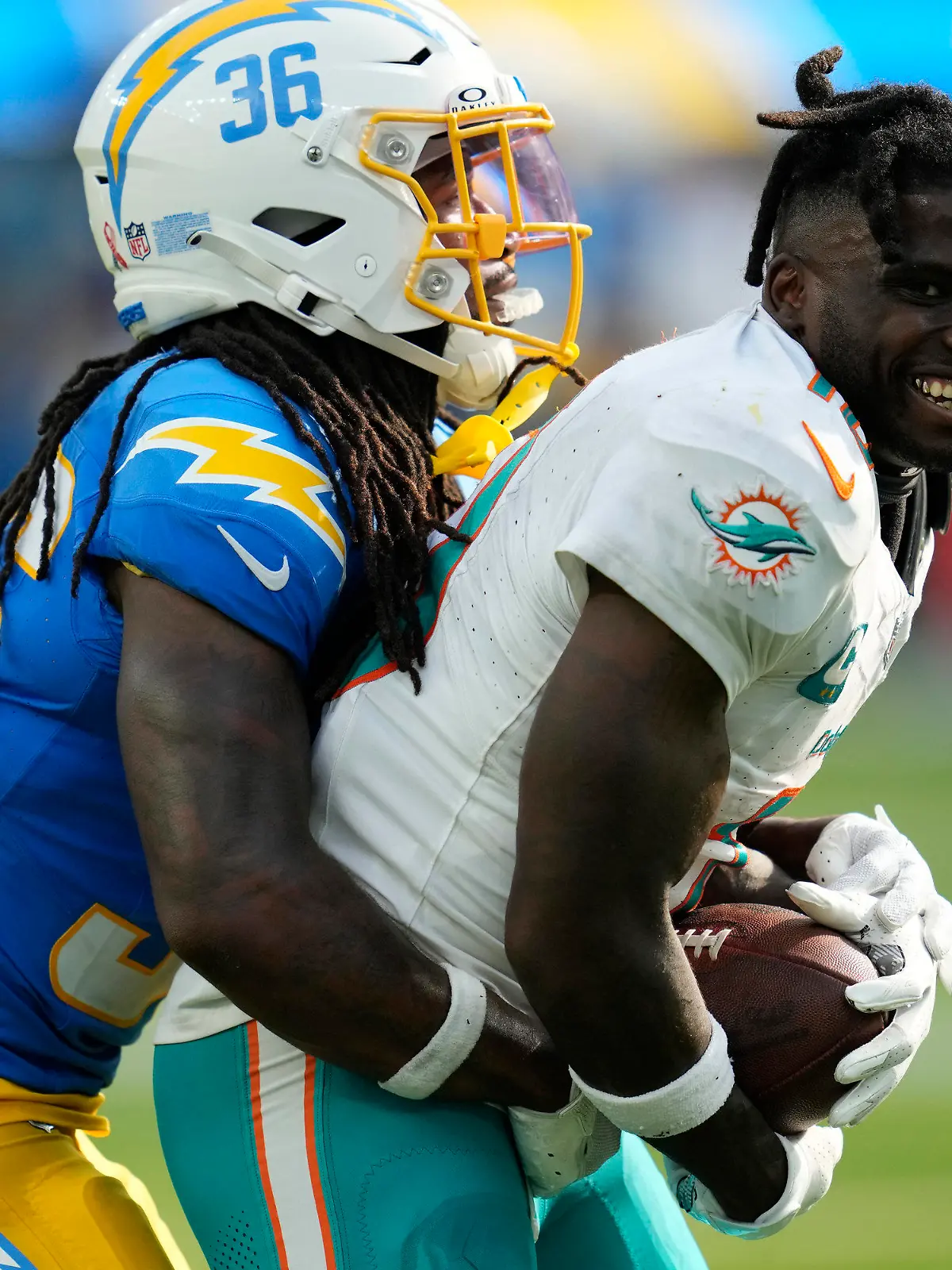 Miami Dolphins wide receiver Tyreek Hill (10) loses his helmet after making a catch next to Los Angeles Chargers cornerback Ja'Sir Taylor during the second half of an NFL football game Sunday, Sept. 10, 2023, in Inglewood, Calif. (AP Photo/Ashley Landis)