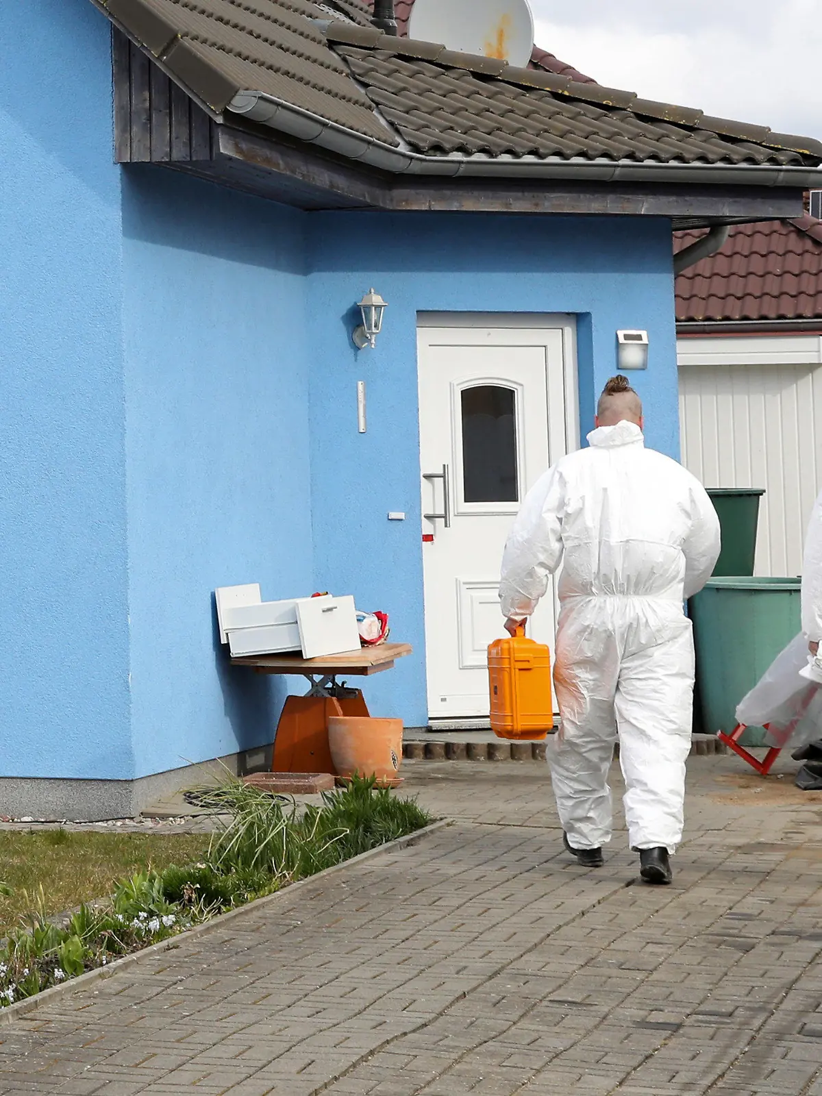 ARCHIV - 01.04.2022, Mecklenburg-Vorpommern, Rövershagen: Mitarbeiter der Kriminaltechnik gehen in ein Haus in Rövershagen, in dem drei Menschen getötet worden sein sollen. Angeklagt ist ein 27-Jähriger. Der Tatverdächtige soll im Februar 2022 seinen Vater, seine Schwester und seine Mutter ermordet haben. Er muss sich nun vor dem Landgericht Rostock verantworten. (zu: dpa «Brutaler Dreifachmord von Rövershagen vor Gericht») Foto: Bernd Wüstneck/dpa - ACHTUNG: Eine Hausnummer wurde aus rechtlichen Gründen gepixelt +++ dpa-Bildfunk +++