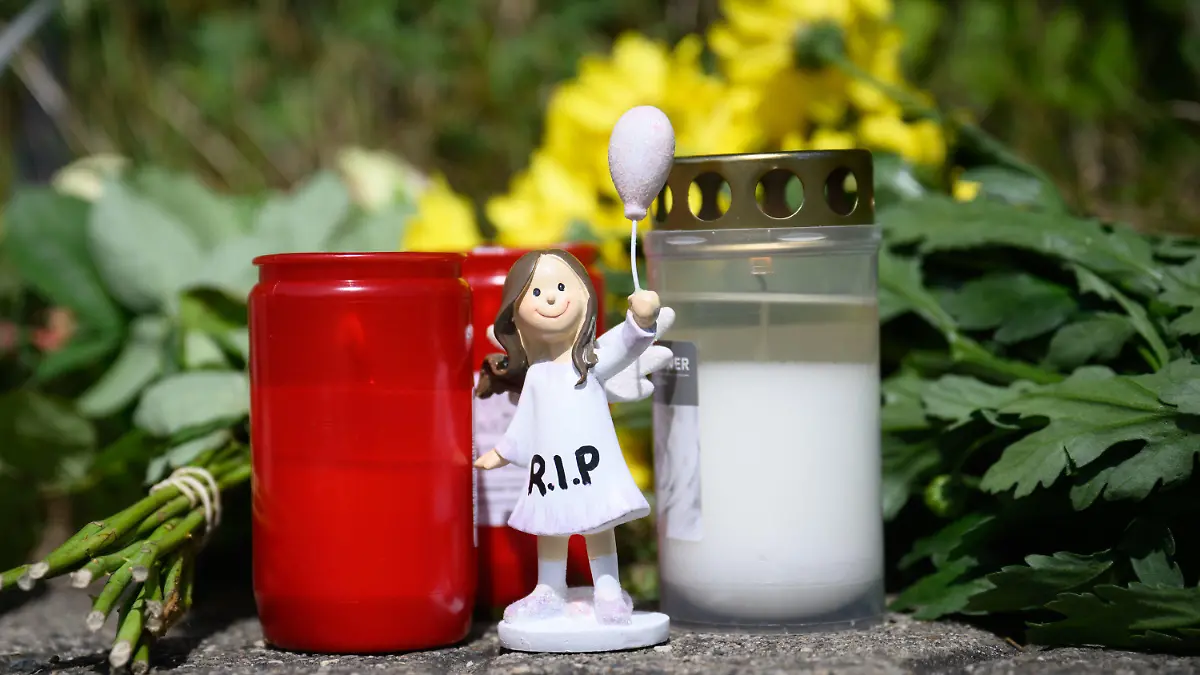 22.06.2022, Niedersachsen, Salzgitter: Kerzen, Blumen und Figuren zum Gedenken an eine getötete 15-jährige liegen an einem Tatort an einer Grünfläche am Hans-Böckler-Ring. Nach dem Fund einer toten 15-Jährigen in Salzgitter gelten zwei Jugendliche als dringend tatverdächtig. Es handele sich um einen 13-Jährigen und einen 14-Jährigen, teilte die Staatsanwaltschaft Braunschweig am Mittwoch mit. Foto: Julian Stratenschulte/dpa +++ dpa-Bildfunk +++
