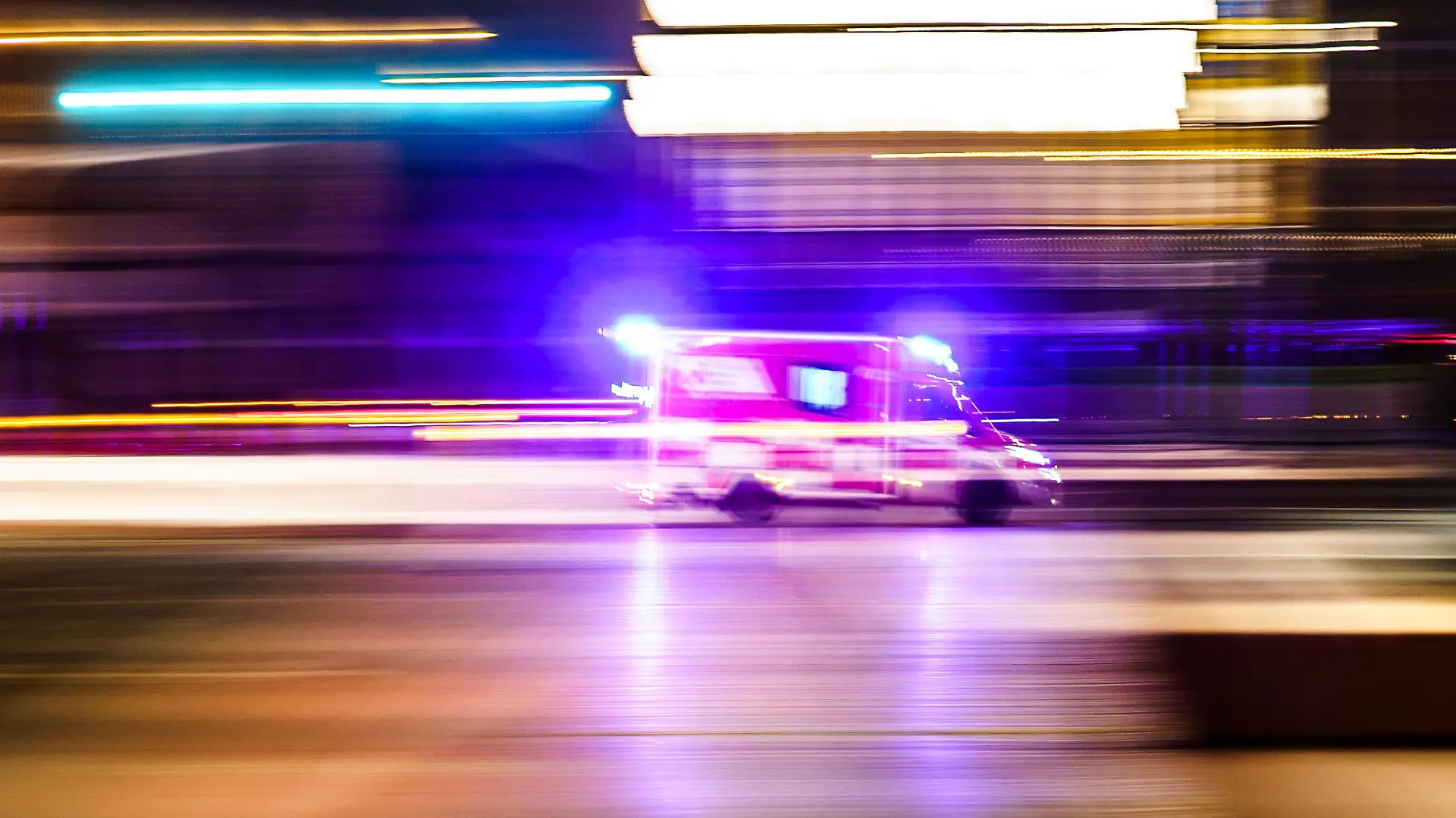 ARCHIV - 02.01.2023, Hessen, Frankfurt/Main: Ein Rettungsfahrzeug ist vor Tagesanbruch mit Blaulicht unterwegs (Aufnahme mit Mitzieheffekt). (zu dpa: «Hessen will mit neuen Krankentransportern Rettungswagen entlasten») Foto: Frank Rumpenhorst/dpa +++ dpa-Bildfunk +++
