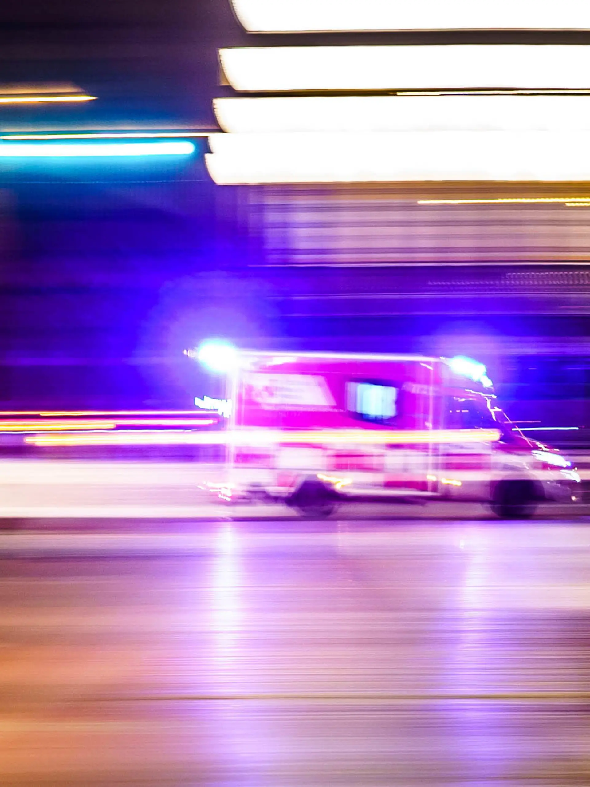 ARCHIV - 02.01.2023, Hessen, Frankfurt/Main: Ein Rettungsfahrzeug ist vor Tagesanbruch mit Blaulicht unterwegs (Aufnahme mit Mitzieheffekt). (zu dpa: «Hessen will mit neuen Krankentransportern Rettungswagen entlasten») Foto: Frank Rumpenhorst/dpa +++ dpa-Bildfunk +++