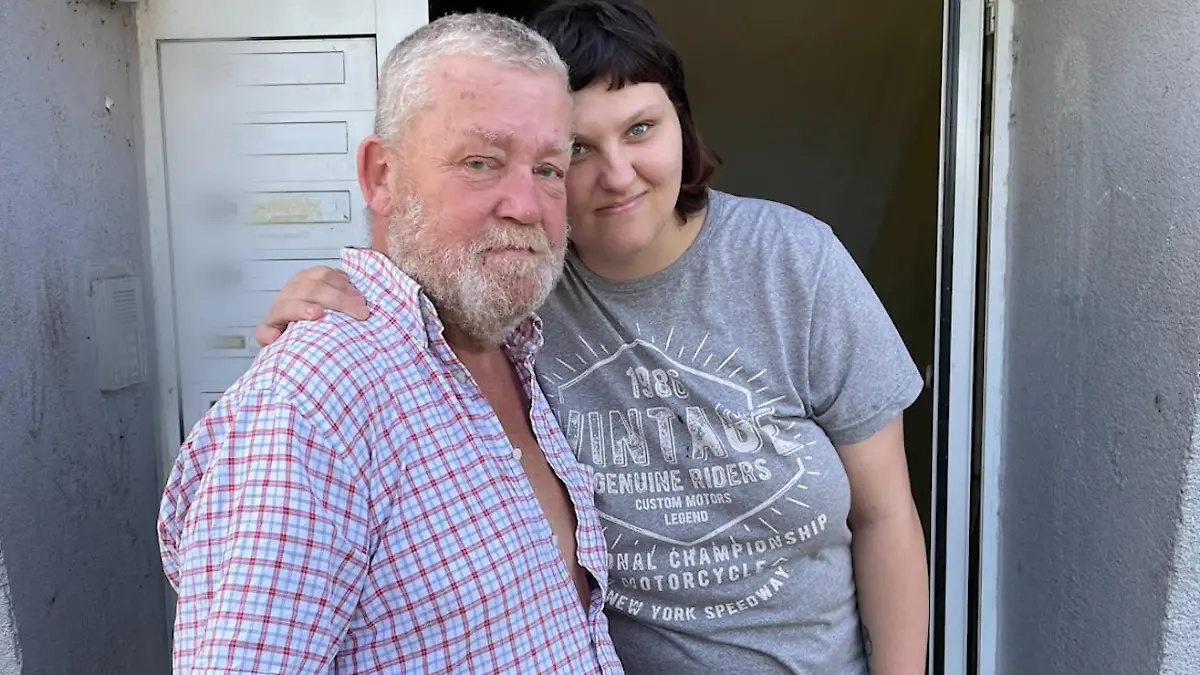 Ein Mann und eine Frau stehen vor einem Hauseingang.