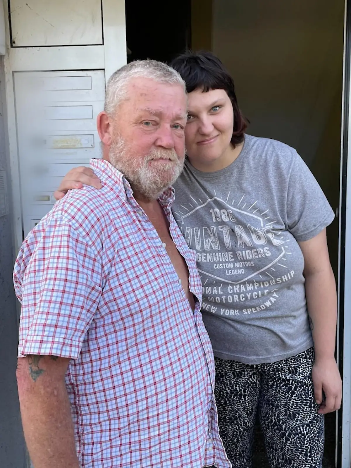 Ein Mann und eine Frau stehen vor einem Hauseingang.