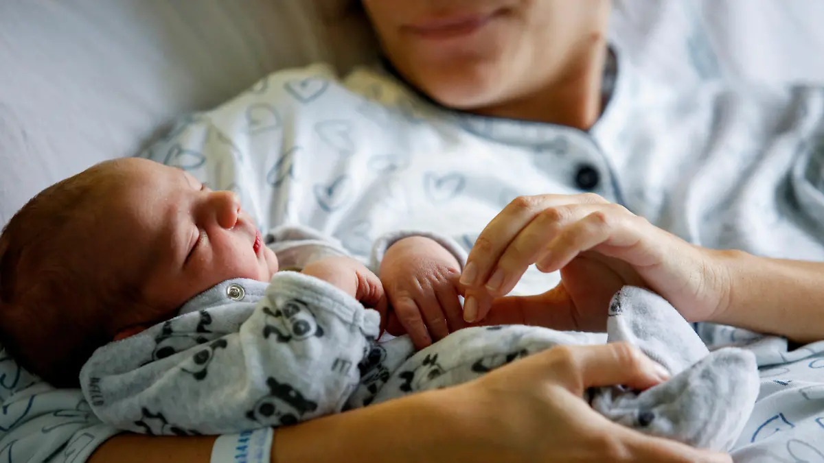 Newborn baby Leonardo rests on his mum's Viviana Valente arms, inside a room of the Santo Spirito Hospital, as the UN forecasts the world will reach 8 billion people around November 15, 2022, in Rome, Italy, November 14, 2022. REUTERS/Remo Casilli