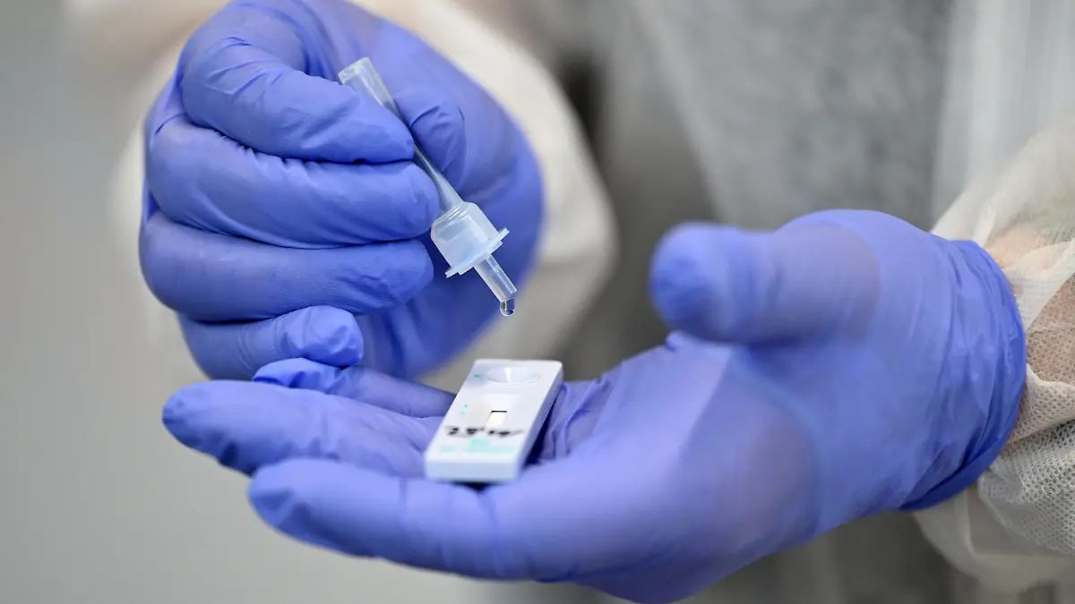 ARCHIV - 02.12.2020, Thüringen, Hildburghausen: Ein Helfer verarbeitet eine Probe für einen Corona-Schnelltest. (zu dpa: «Lockerungen bei Regeln für Corona-Quarantäne und Klinikbesucher») Foto: Martin Schutt/dpa-Zentralbild/dpa +++ dpa-Bildfunk +++