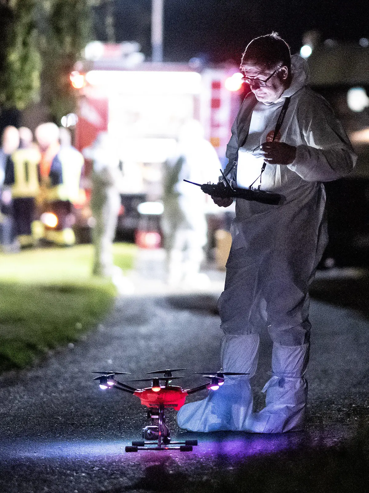 28.09.2023, Hessen, Bad Emstal: Ein Mitarbeiter der Spurensicherung steht mit einer Drohne auf einem Waldweg. In Bad-Emstal, im Landkreis Kassel, ist eine Frauenleiche entdeckt worden. Die Polizei schloss am Donnerstagabend ein Verbrechen nicht aus. Foto: Swen Pförtner/dpa +++ dpa-Bildfunk +++