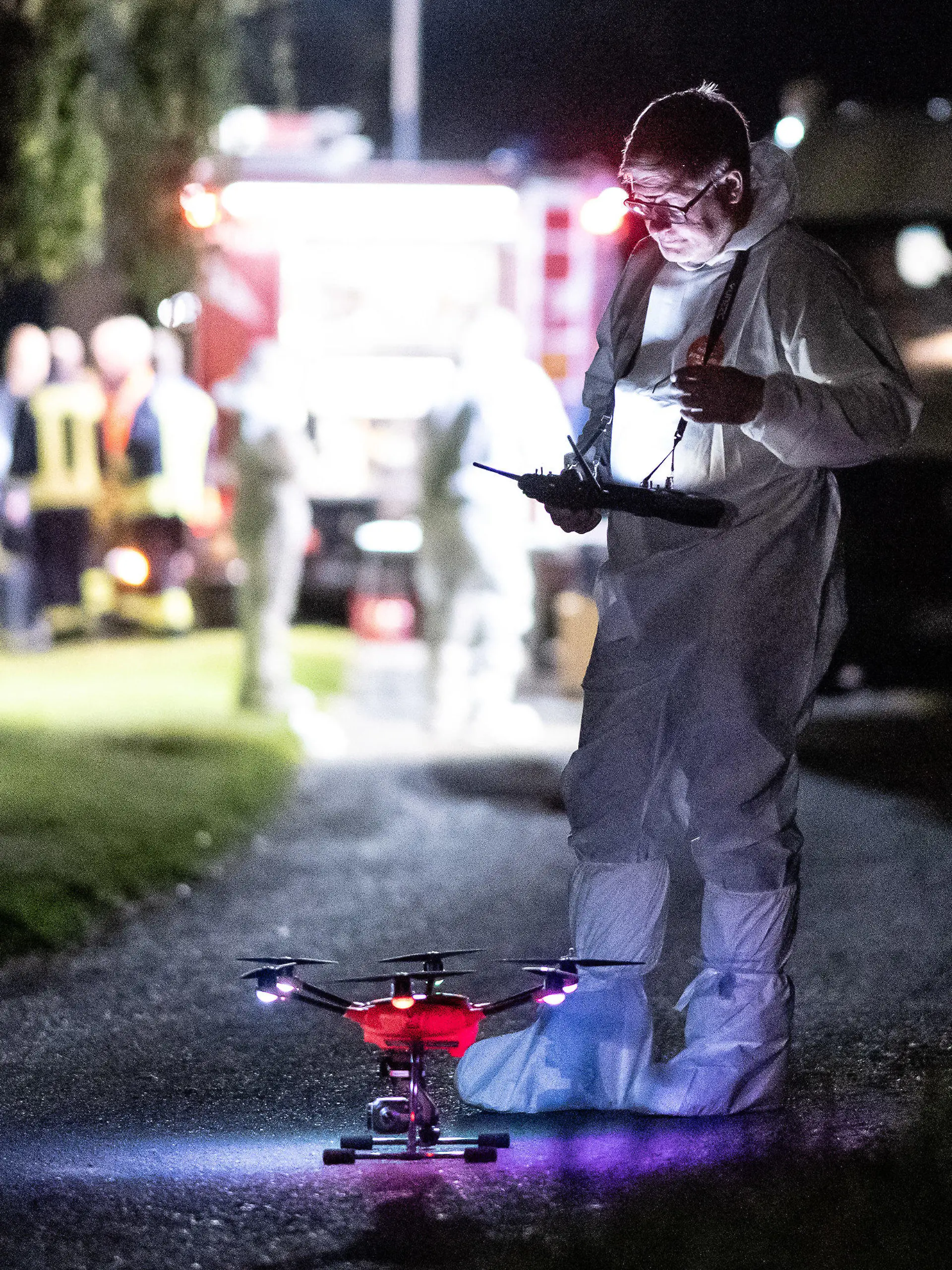 28.09.2023, Hessen, Bad Emstal: Ein Mitarbeiter der Spurensicherung steht mit einer Drohne auf einem Waldweg. In Bad-Emstal, im Landkreis Kassel, ist eine Frauenleiche entdeckt worden. Die Polizei schloss am Donnerstagabend ein Verbrechen nicht aus. Foto: Swen Pförtner/dpa +++ dpa-Bildfunk +++