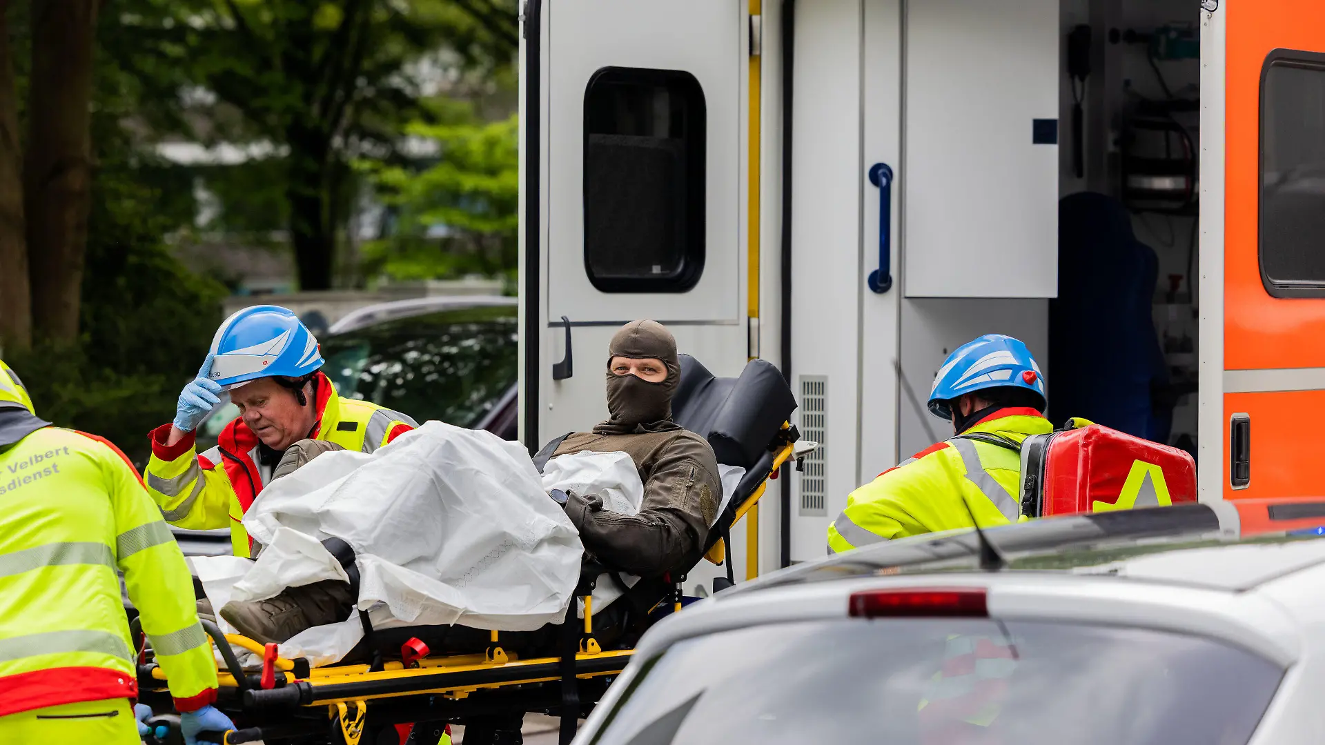 11.05.2023, Nordrhein-Westfalen, Ratingen: Ein verletzter Polizeibeamter wird vor einem Hochhaus in einen Krankenwagen gebracht. Bei einer Explosion in einem Hochhaus in Ratingen am Donnerstagvormittag wurden mehrere Menschen verletzt - darunter auch Polizisten und Einsatzkräfte der Feuerwehr. Foto: Rolf Vennenbernd/dpa +++ dpa-Bildfunk +++