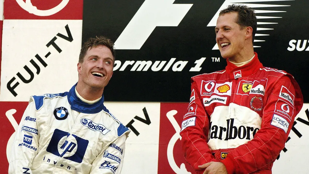 ARCHIV - Der deutsche Formel-1-Pilot Michael Schumacher (r) vom Team Ferrari lacht am 10.10.2004 in Suzuka nach seinem Sieg beim Großen Preis von Japan neben seinem Bruder Ralf (BMW-Williams), der Zweiter wurde. Die nächste Schumacher-Karriere ist beendet und damit das erfolgreichste Bruder-Paar endgültig Rennsportgeschichte. Wenige Monate nachdem sich Michael in die Formel-1-Rente verabschiedet hat, verkündete am Samstag (16.03.2013) Ralf Schumacher das Ende seines Fahrer-Engagements in der DTM. Foto: Oliver Multhaup/dpa +++(c) dpa - Bildfunk+++