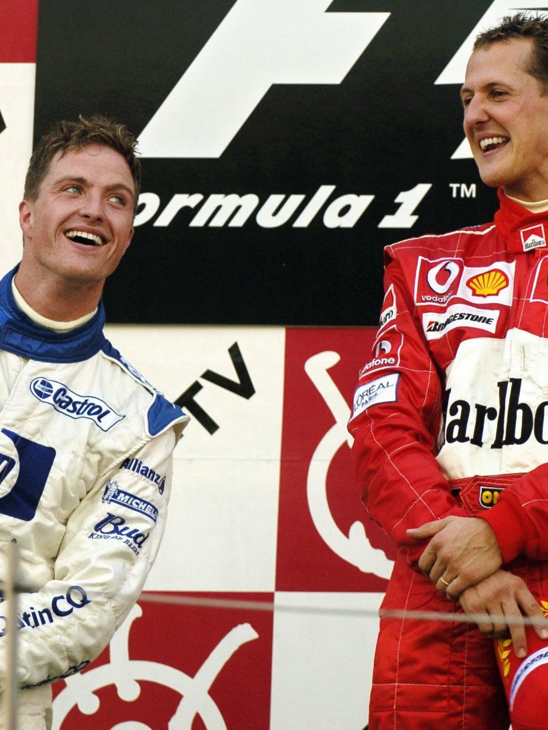 ARCHIV - Der deutsche Formel-1-Pilot Michael Schumacher (r) vom Team Ferrari lacht am 10.10.2004 in Suzuka nach seinem Sieg beim Großen Preis von Japan neben seinem Bruder Ralf (BMW-Williams), der Zweiter wurde. Die nächste Schumacher-Karriere ist beendet und damit das erfolgreichste Bruder-Paar endgültig Rennsportgeschichte. Wenige Monate nachdem sich Michael in die Formel-1-Rente verabschiedet hat, verkündete am Samstag (16.03.2013) Ralf Schumacher das Ende seines Fahrer-Engagements in der DTM. Foto: Oliver Multhaup/dpa +++(c) dpa - Bildfunk+++