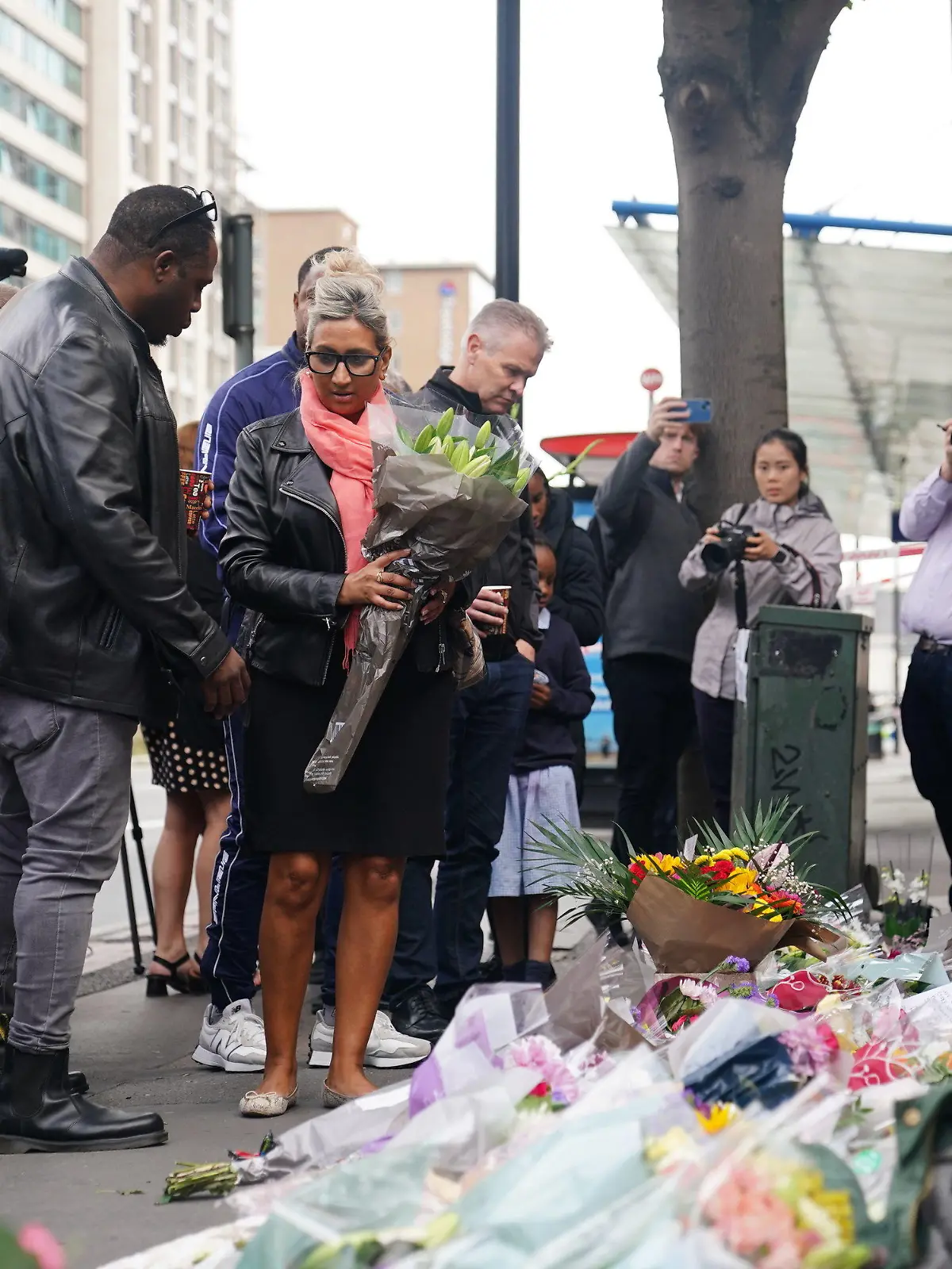 28.09.2023, Großbritannien, London: Menschen legen Blumen am Tatort in Croydon, Südlondon, nieder, wo ein 15-jähriges Mädchen am Mittwochmorgen (27.09.2023) auf dem Weg zur Schule erstochen wurde. Foto: James Manning/PA Wire/dpa +++ dpa-Bildfunk +++