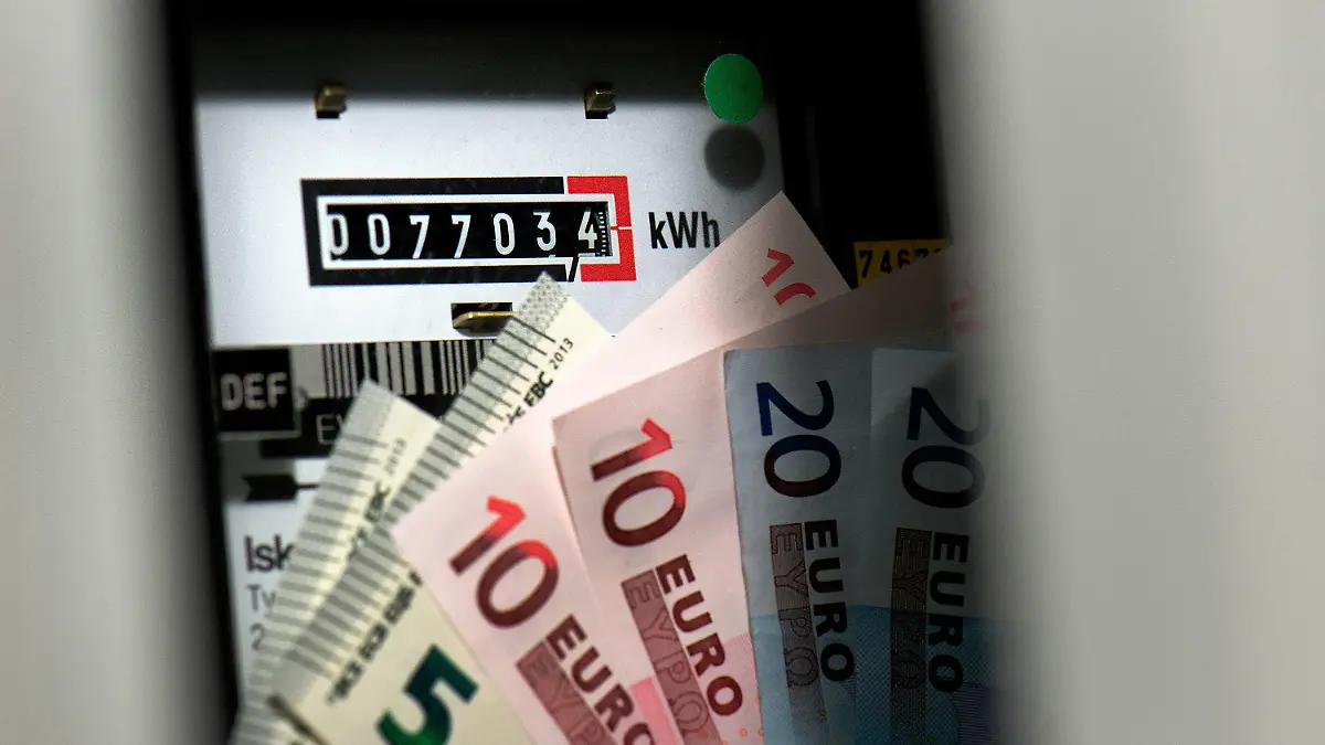 ILLUSTRATION - Vor einem Wechselstromzähler in einem Stromkasten eines Haushaltes in Dresden (Sachsen) sind am 15.10.2013 mehrere Euro Geldscheine zu sehen. Die Verbraucher in Deutschland müssen sich auf spürbare Strompreiserhöhungen einstellen. Die über den Strompreis zu zahlende Umlage zur Förderung erneuerbarer Energien werde für 2014 auf den Rekordwert von 6,240 Cent je Kilowattstunde festgesetzt, teilte der für die Verwaltung der Förderzahlungen mitzuständige Übertragungsnetzbetreiber TransnetBW mit. Foto: Arno Burgi/dpa +++(c) dpa - Bildfunk+++