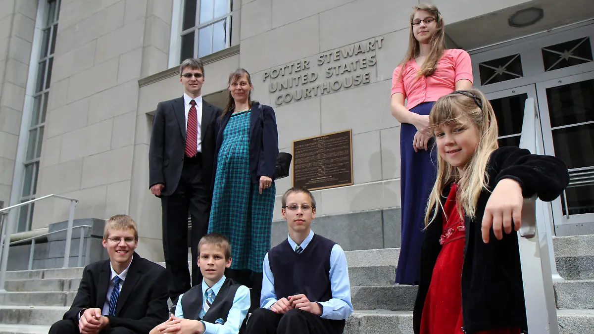Uwe and mother Hannolure Romeike with their children, Daniel, 16, Joshua, 13, Christian, 11, Lydia, 15 and Damaris, 7, left to right, pose for photos outside the federal courthouse in Cincinnati Tuesday, April 23, 2013. A federal appeals court is weighing whether the Romeike family, from Germany but now live in Morristown, Tenn. and home-school their children, should be granted asylum and be allowed to continue living in Tennessee. (AP Photo/Tom Uhlman)