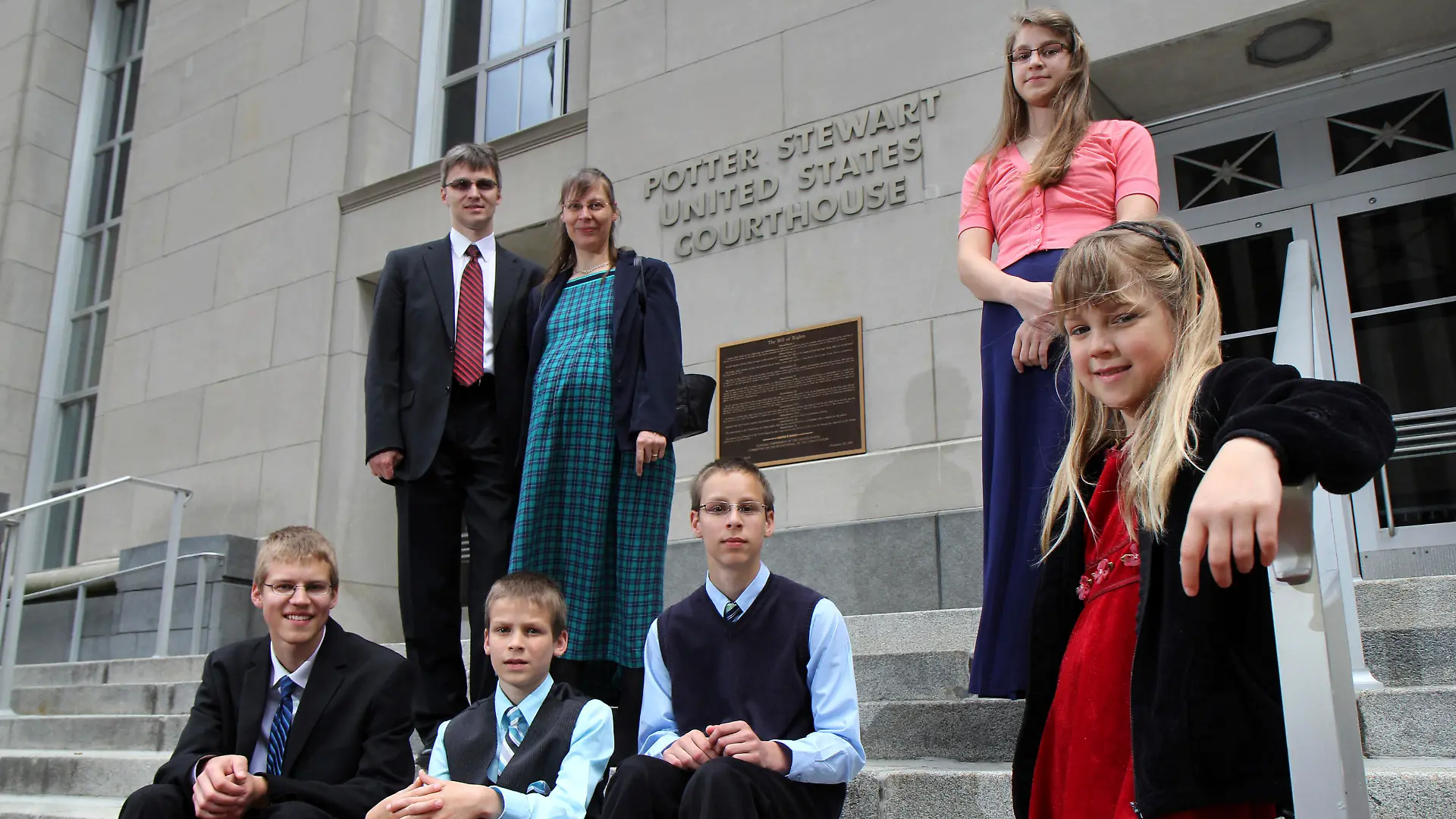 Uwe and mother Hannolure Romeike with their children, Daniel, 16, Joshua, 13, Christian, 11, Lydia, 15 and Damaris, 7, left to right, pose for photos outside the federal courthouse in Cincinnati Tuesday, April 23, 2013. A federal appeals court is weighing whether the Romeike family, from Germany but now live in Morristown, Tenn. and home-school their children, should be granted asylum and be allowed to continue living in Tennessee. (AP Photo/Tom Uhlman)