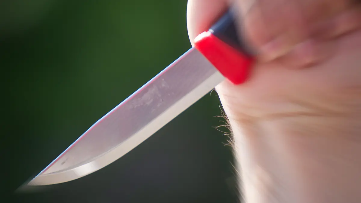 Symbolbild Messerattacke: Nahaufnahme von einem Messer in der Hand eines Mannes
