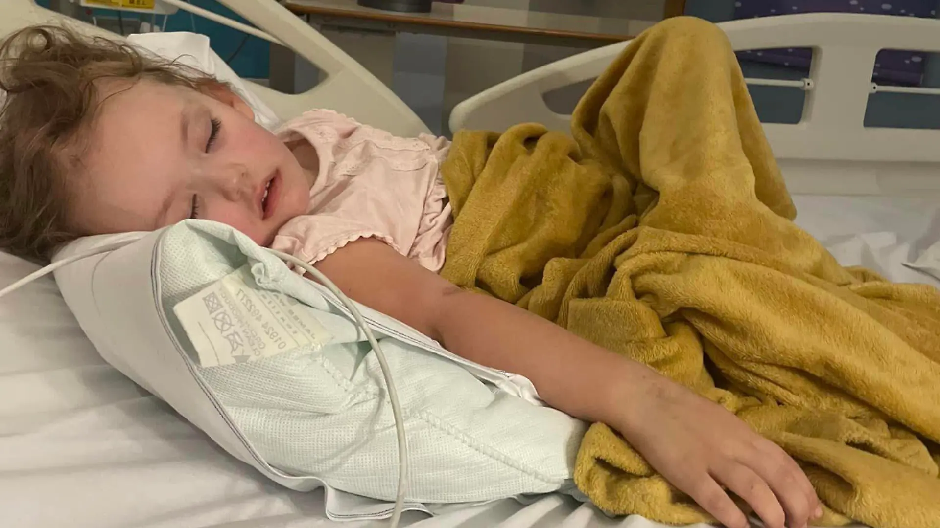 Story from Jam Press (Cancer Skydive)

Pictured: Raeyah in hospital.

Dad devastated as daughter’s ‘growing pains’ turn out to be cancer – sharing story to help other parents avoid the same fate.

A dad has opened up about how his daughter’s “growing pains” were actually a sign of her cancer returning – sharing his painful story to help other parents.

Tomorrow (30 September), Kevin Rice, 40, from Bristol is set to face one of his fears: skydiving.

The dad is taking on the adventure in memory of his child, Raeyah, who tragically died from a Wilm’s tumour (kidney cancer) relapse earlier this year when she was just four years old.

In a horrible twist of fate, the child, who was originally diagnosed in December 2021, was given the all-clear after treatment – but relapsed in January 2023.

Just two months later, she lost her battle with the aggressive disease.

When builder Kevin and his wife, Rebecca, 42, first lost Raeyah, they were inconsolable.

And although his heart remains broken, the dad-of-three credits his “daredevil” daughter with “taking his fear away” – as he does whatever he can to raise funds and awareness of her illness.

“I’m a builder by trade and when my first son, Mitchell, was born, I automatically had a fear of anything that was going to harm me – and take me away from him,” Kevin told Jam Press.

“So I wouldn’t go up ladders or do anything out of the ordinary and I stayed like that until Raeyah passed away.

“Now, I’m not scared about jumping from a plane.

“It’s a very weird way of looking at it but when Raeyah left, she took all of my fear with her.

“My little girl was crazy and engaging, I can only imagine what she’d be saying [about the skydive].

“She was a daredevil, she had fire.”

Kevin and Rebecca, who also have two sons (Mitchell, 13, and Mason, 10) also want to share the warning signs of cancer for other parents to look out for.

Alarm bells first began ringing on Boxing Day l