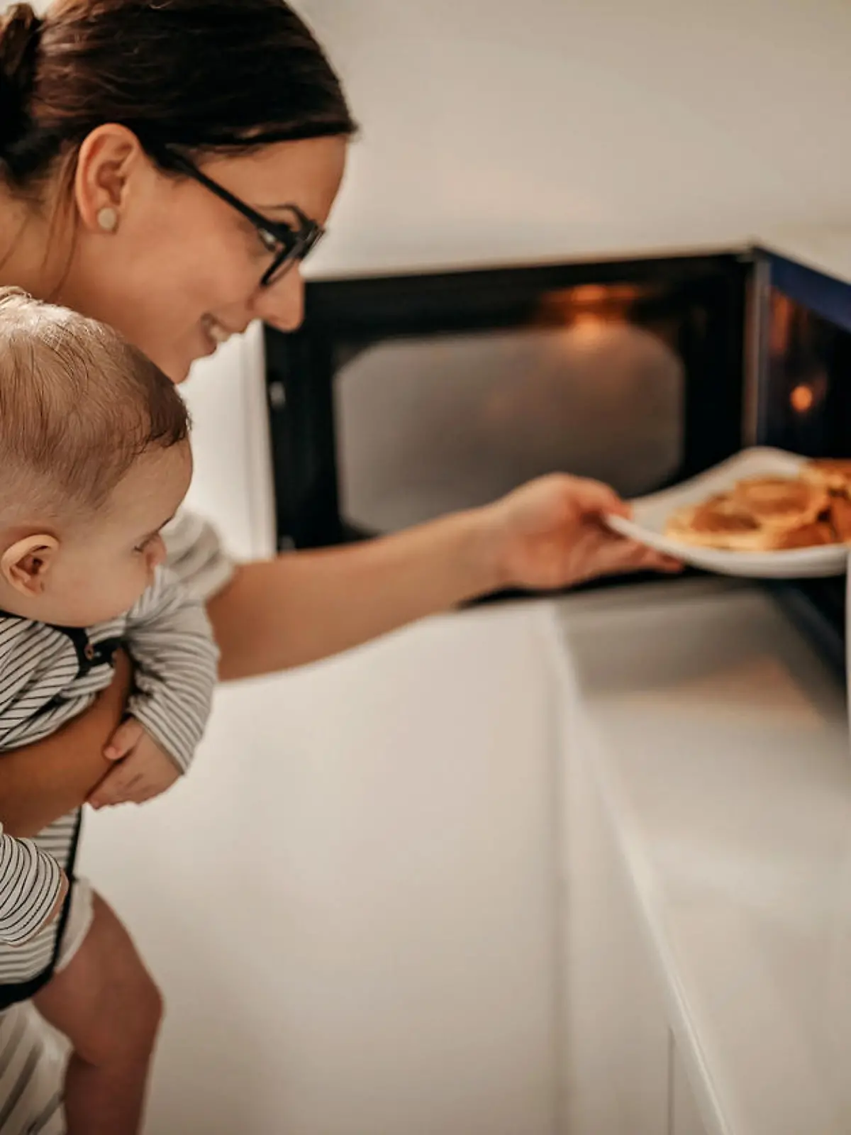 Mother preparing food with baby in arms