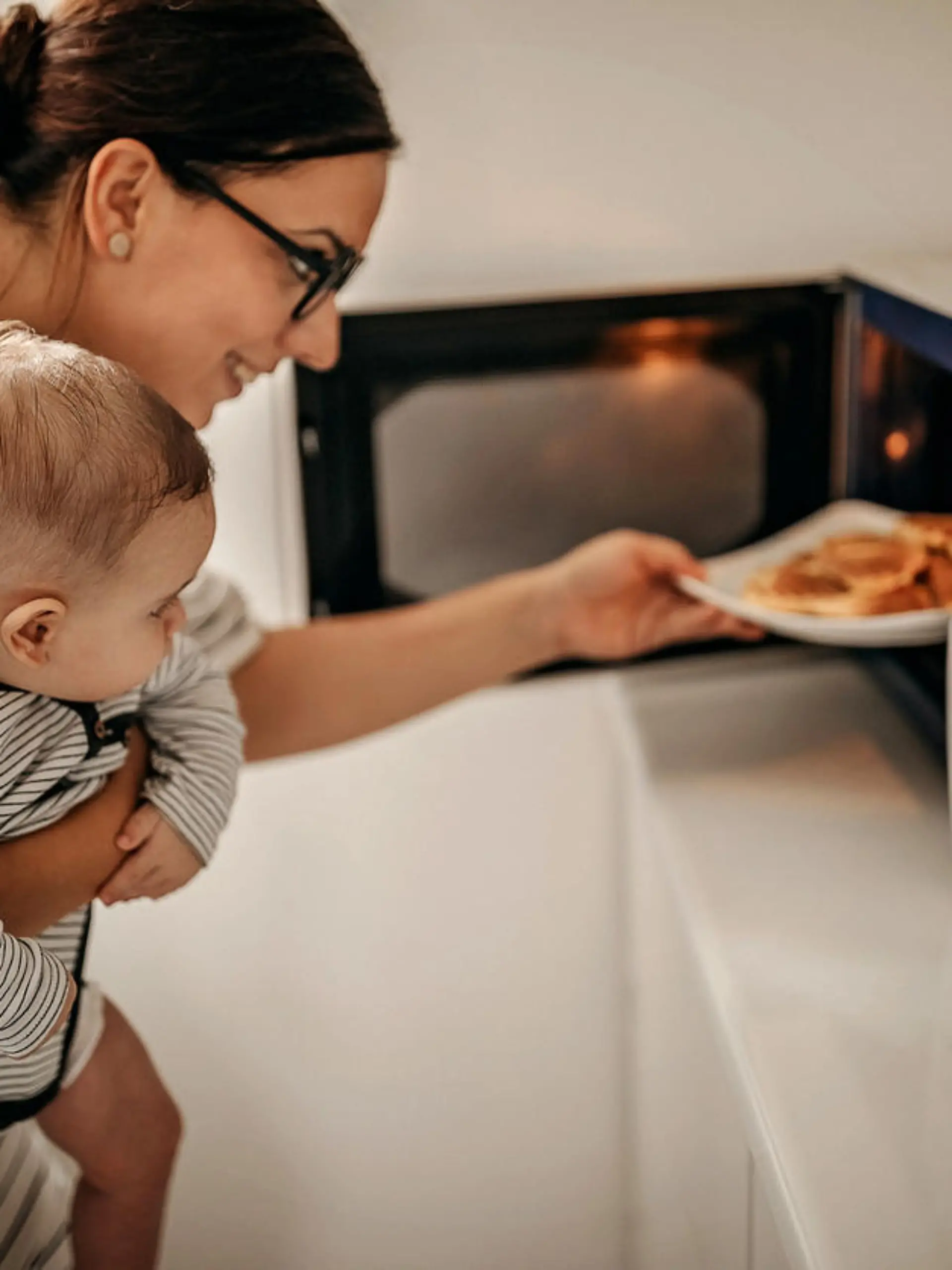 Mother preparing food with baby in arms