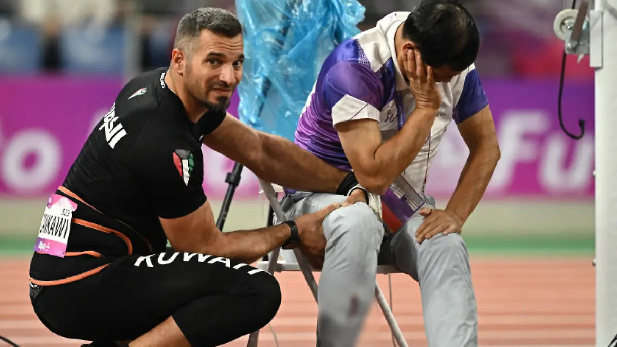 Asian Games - Hangzhou 2022 - Athletics - Olympic Sports Centre Stadium, Hangzhou, China - September 30, 2023 A judge is injured after Kuwait's Ali Zankawi throws the hammer through the net during the Men's Hammer Throw Final