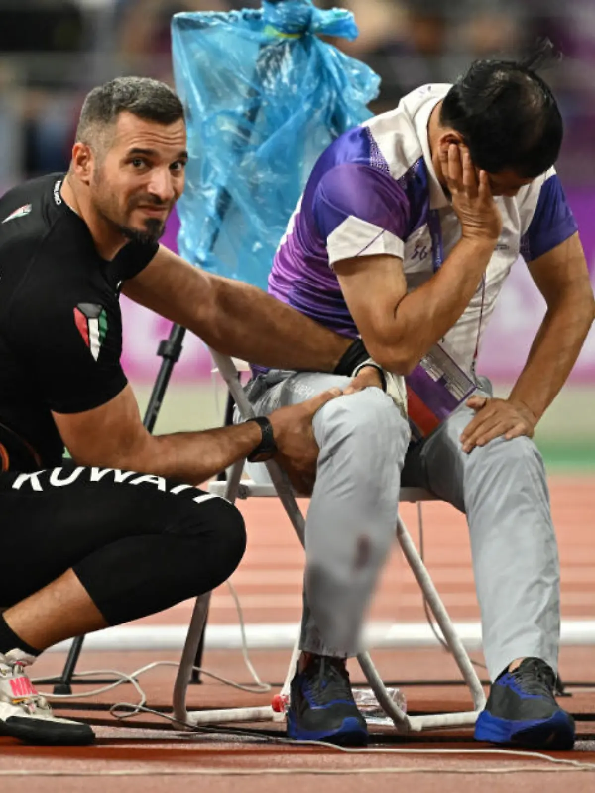 Asian Games - Hangzhou 2022 - Athletics - Olympic Sports Centre Stadium, Hangzhou, China - September 30, 2023 A judge is injured after Kuwait's Ali Zankawi throws the hammer through the net during the Men's Hammer Throw Final