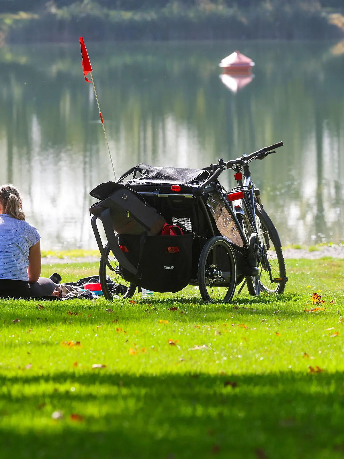 01.10.2023, Baden-Württemberg, Ertingen: Ein Mann und eine Frau sitzen neben ihren Fahrrädern an einem See in der Sonne Foto: Thomas Warnack/dpa +++ dpa-Bildfunk +++