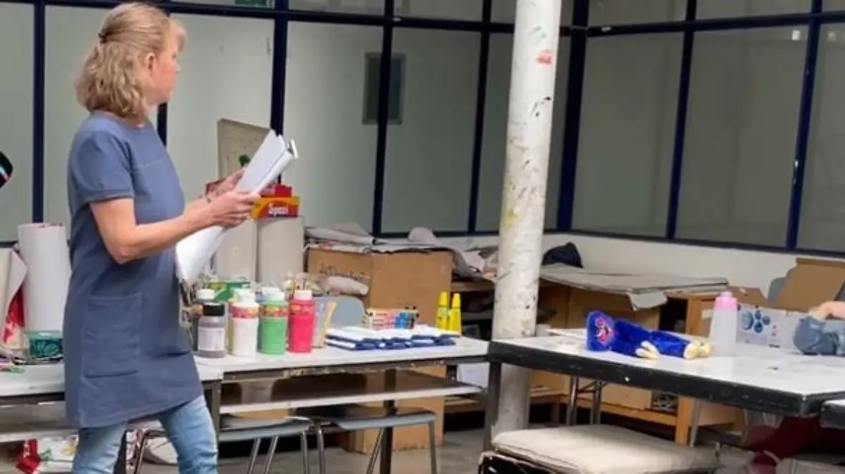 Die Kunsttherapeutin verteilt Blätter, während die Materialien dahinter schon bereitstehen.
