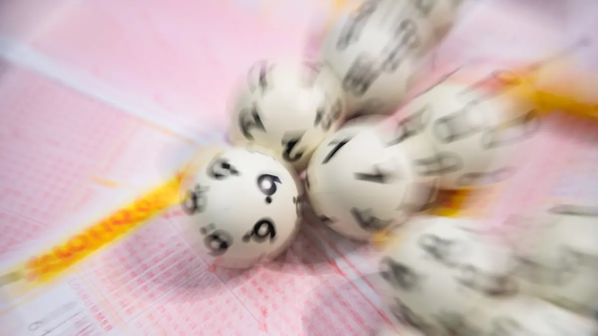 ARCHIV - 08.01.2020, Baden-Württemberg, Stuttgart: Lotto-Kugeln liegen auf einem Lottoschein (gestellte Szene - Aufnahme mit Zoomeffekt). Seit 20 Jahren spielen mehrere Kollegen aus dem Brandenburger Kreis Potsdam-Mittelmark gemeinsam Lotto und tippen dabei immer ein und dieselbe Zahlenkombination. Nun sind sie die Jackpot-Knacker. (zu dpa "Lotto-Millionen-Gewinn für Tipp-Gemeinschaft aus Potsdam-Mittelmark") Foto: Tom Weller/dpa +++ dpa-Bildfunk +++