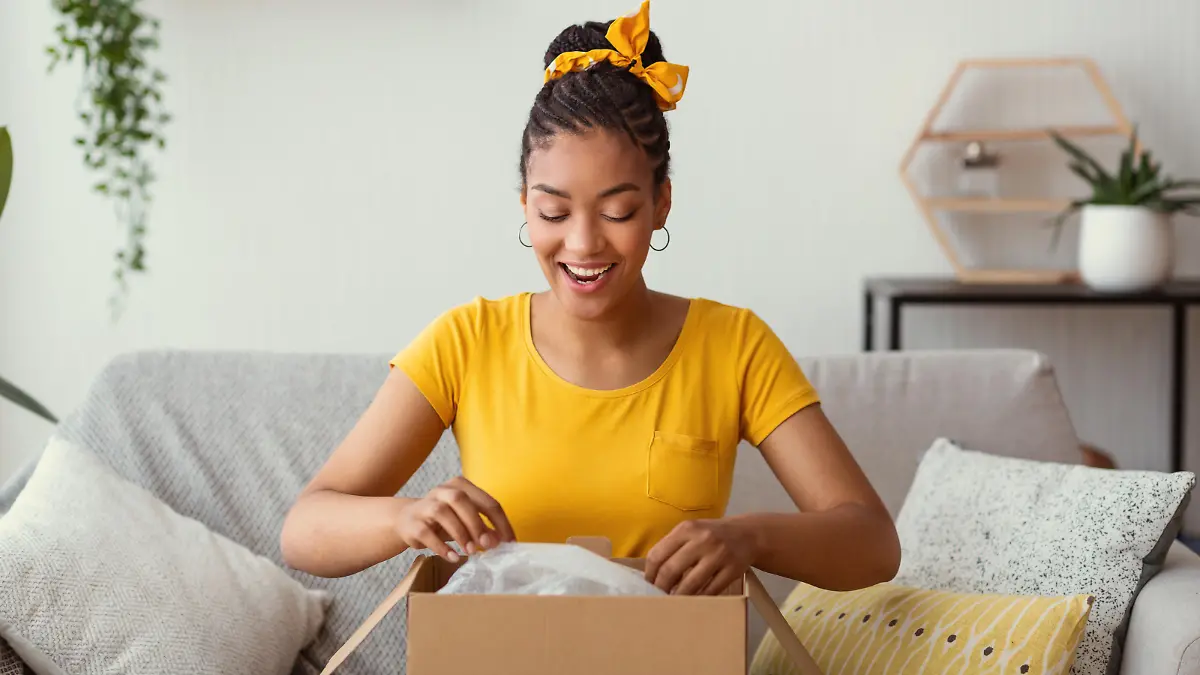 Prime Day: Frau öffnet Paket und freut sich.