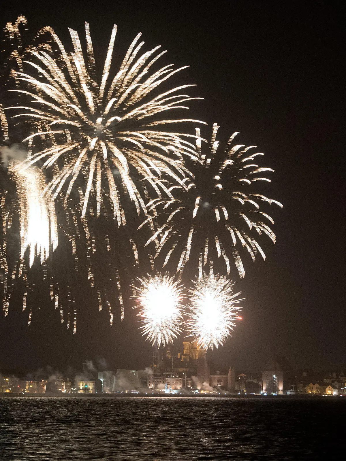 ARCHIV - 31.12.2019, Mecklenburg-Vorpommern, Stralsund: Ein Silvesterfeuerwerk zum Jahreswechsel 2020 leuchtet im Hafen der Hansestadt. Die Kommunen erwarten in diesem Jahr keine Beschränkungen beim Pyrotechnik-Verkauf und bei Versammlungen wie in den vergangnen Jahren. (zu dpa "Kommunen: Kein allgemeines Böllerverbot an Silvester erwartet") Foto: Stefan Sauer/dpa +++ dpa-Bildfunk +++