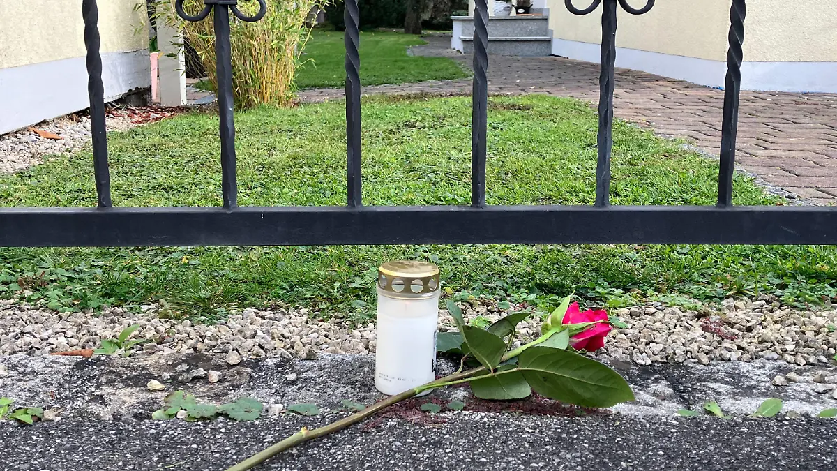 12.11.2022, Weilheim: Eine Rose liegt neben einer Kerze vor einer Gartentür an einem Wohnhaus. In Weilheim hat sich eine Bluttat mit vier Toten ereignet. Foto: Jacqueline Melcher/dpa +++ dpa-Bildfunk +++