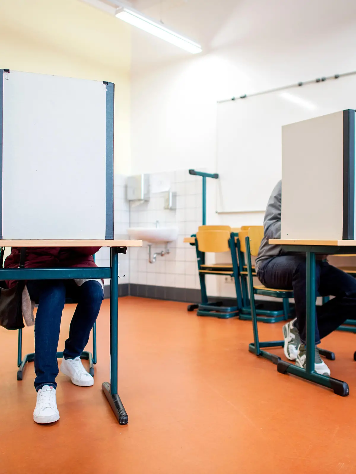 Wähler sitzen in einem Wahlraum in der Lutherschule hinter einem Sichtschutz. Niedersachsen wählt am 09.10.2022 einen neuen Landtag.