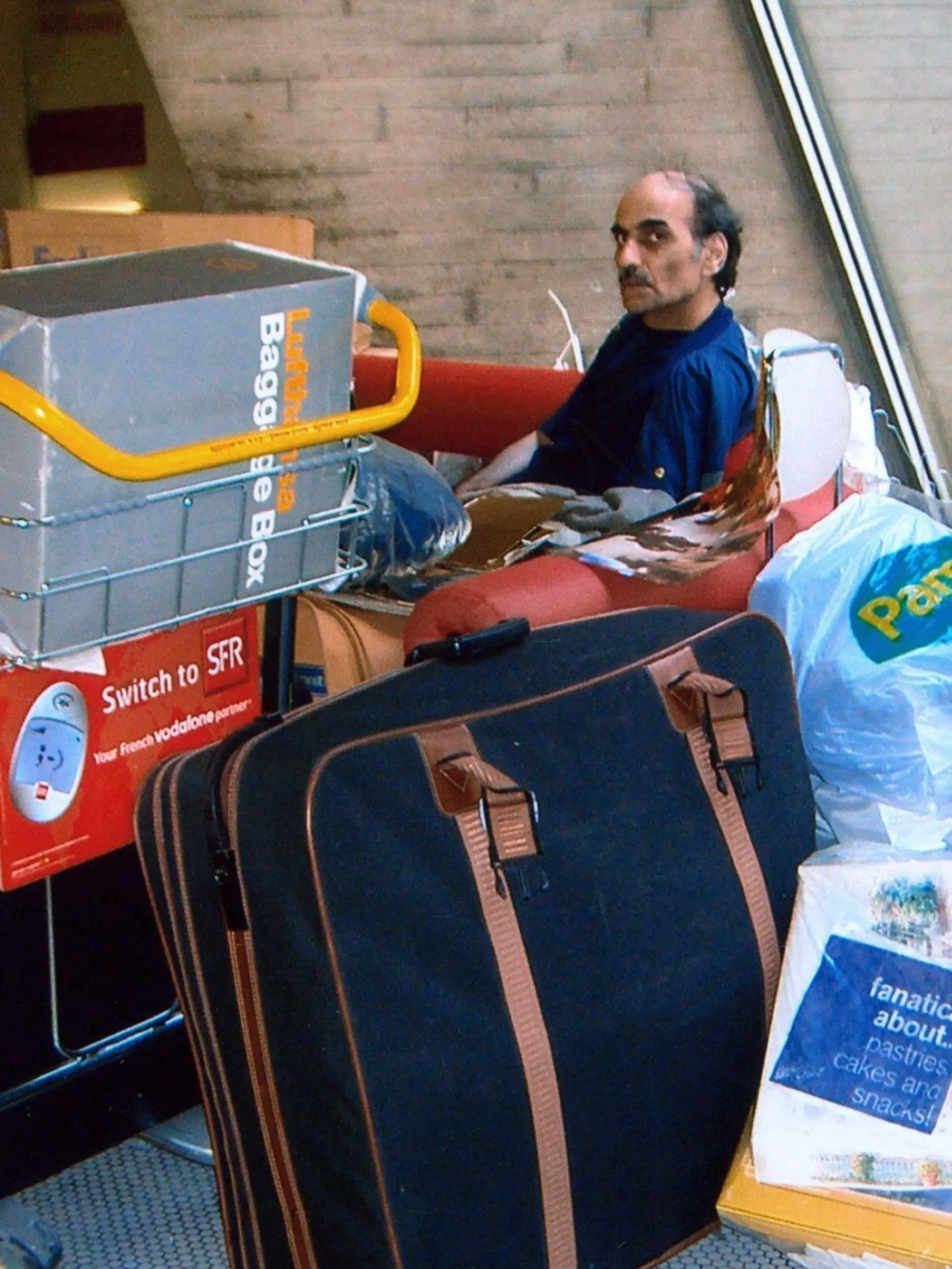 Merhan Karimi Nassiri lebt seit 16 Jahren auf dem Pariser Flughafen Charles de Gaulle (Foto vom 04.09.2004). Seitdem wartet er hier auf seinen Pass, um dann nach Kanada auswandern zu können, erzählt er. Eine halbkreisförmige rote Bank ist seine Wohnstatt. Alle Beschäftigten des Flughafens kennen und respektieren ihn, seine Anwesenheit wird toleriert. Die Lebensgeschichte Nassiris ist so skurril, dass sich US-Regisseur Spielberg die Rechte an der Story sicherte. Im Oktober soll sein Film "Terminal" mit Tom Hanks in der Hauptrolle in die deutschen Kinos kommen. Foto: Stephan Isernhagen dpa