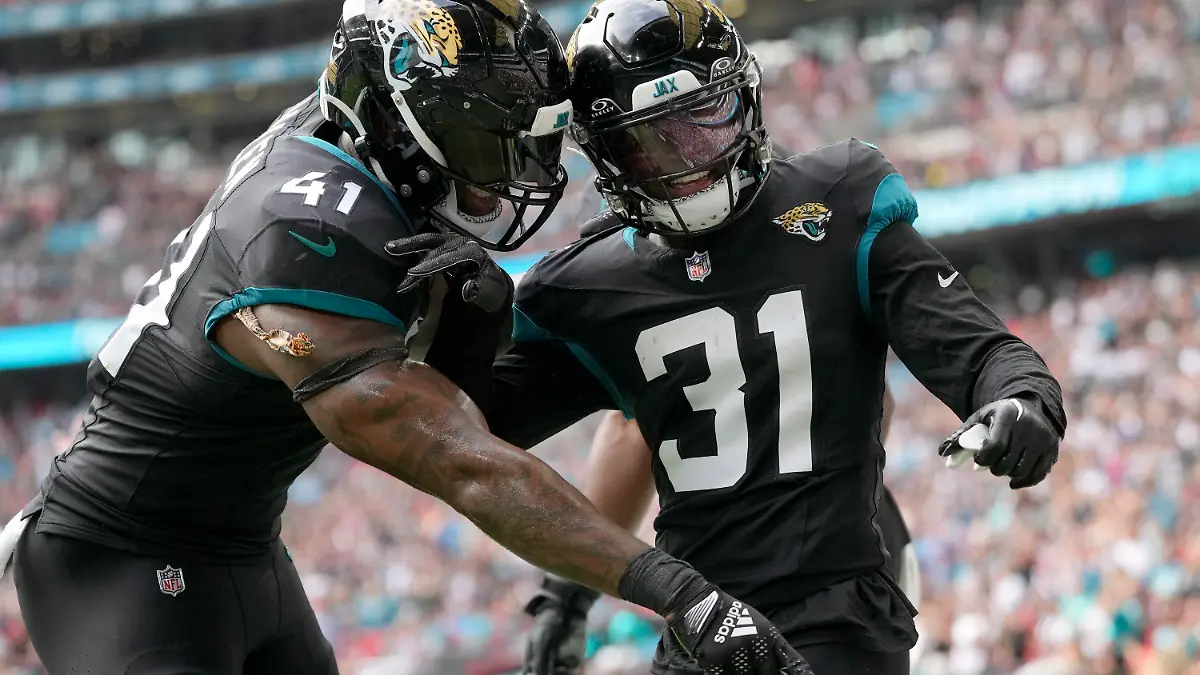 Jacksonville Jaguars cornerback Darious Williams (31) celebrates with Jacksonville Jaguars linebacker Josh Allen (41) after scoring a touchdown during an NFL football game between the Atlanta Falcons and the Jacksonville Jaguars at Wembley stadium in London, Sunday, Oct. 1, 2023. (AP Photo/Kirsty Wigglesworth)