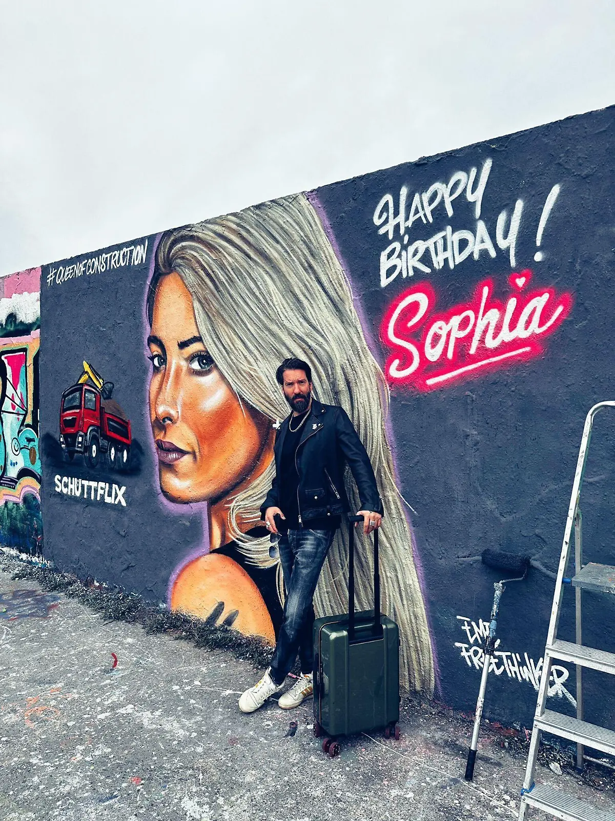 „The BossHoss“-Star Alec Voelkel vor einem Graffiti von Sophia Thomallas Gesicht.