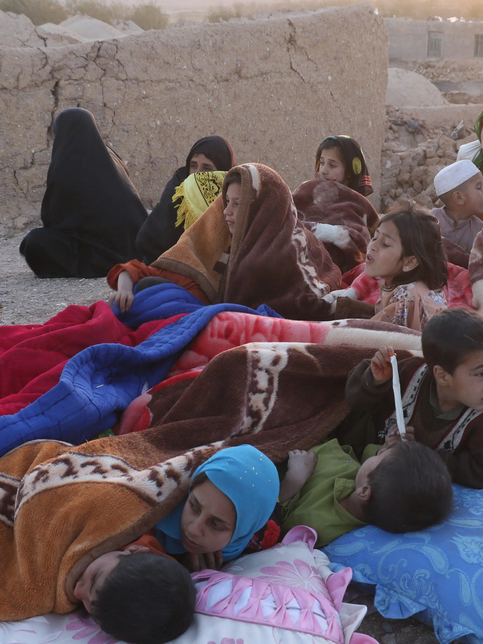07.10.2023, Afghanistan, Herat: Menschen, die von Erdbeben betroffen sind, ruhen im Freien aus. Nach mehreren starken Erdbeben in Afghanistan sind nach Einschätzungen der Vereinten Nationen (UN) mehr als 100 Menschen ums Leben gekommen. Zudem seien in der betroffenen Region Hunderte Häuser zerstört worden, teilte das UN-Nothilfebüro OCHA am Samstag mit. Foto: Mashal/XinHua/dpa - ACHTUNG: Nur zur redaktionellen Verwendung und nur mit vollständiger Nennung des vorstehenden Credits +++ dpa-Bildfunk +++
