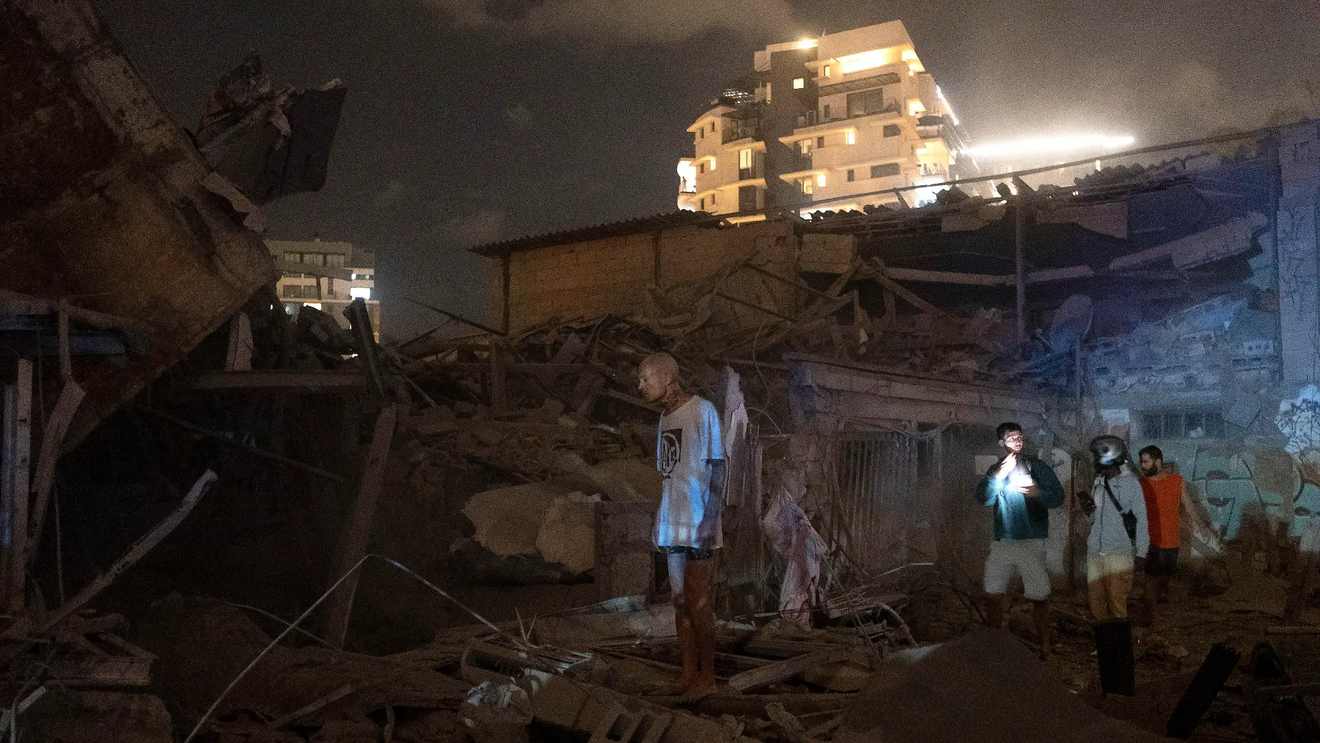 07.10.2023, Israel, Tel Aviv: Menschen betrachten die Schäden einer aus dem Gazastreifen abgefeuerten Rakete in Tel Aviv. Die islamistische Hamas hat einen großangelegten Überraschungsangriff auf Israel gestartet. Die EU, die USA und Israel stuft die Hamas als Terrororganisation ein. Das israelische Militär entgegnete mit dem Beschuss von Zielen der Hamas im Gazastreifen. Foto: Moti Milrod/AP/dpa +++ dpa-Bildfunk +++