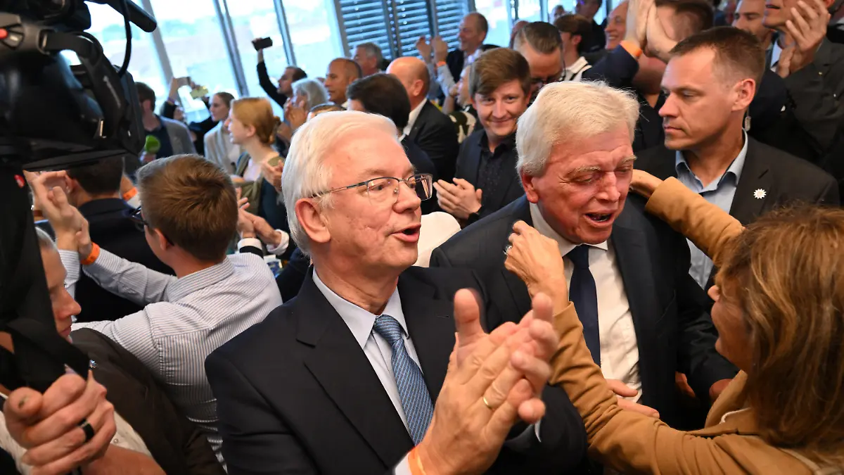 08.10.2023, Hessen, Wiesbaden: Roland Koch (CDU, l-r), ehemaliger Ministerpräsident des Landes Hessen, Volker Bouffier (CDU), ehemaliger Ministerpräsident des Landes Hessen, und seine Frau Ursula Bouffier (vorne) reagieren nach der Veröffentlichung der ersten Prognose zur Landtagswahl in Hessen. Am Sonntag fand in Hessen die Wahl zum 21. hessischen Landtag statt. Foto: Arne Dedert/dpa +++ dpa-Bildfunk +++