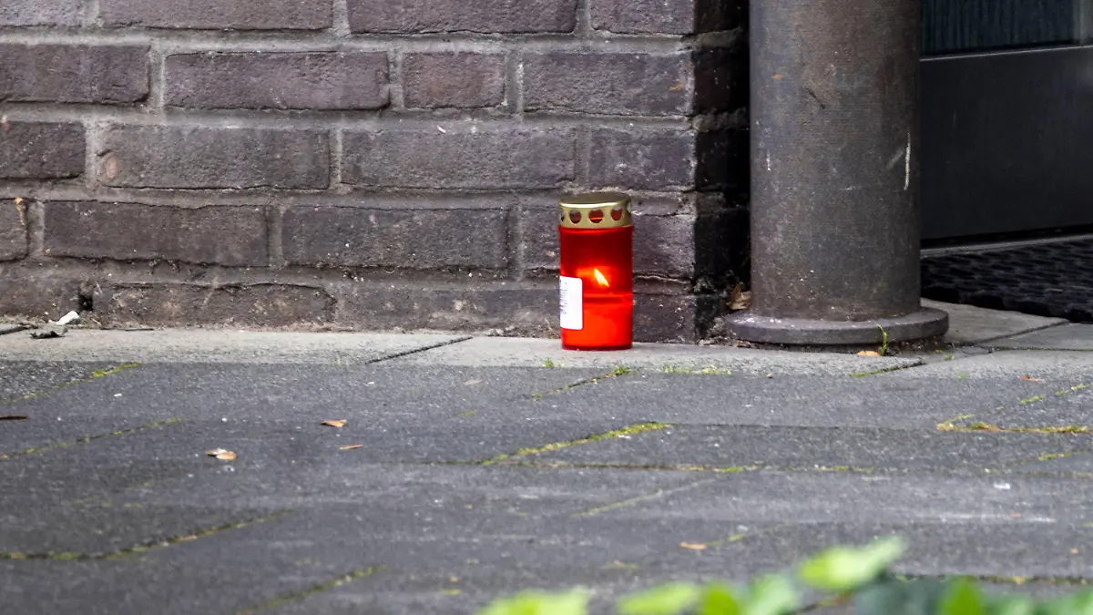 08.10.2023, Nordrhein-Westfalen, Dinslaken: Eine Kerze vor dem Wohnhaus der Familie. Ein Vater soll seine dreijährige Tochter zur Strafe in einen Keller gesperrt haben, wo es an Erbrochenem erstickt sei. Anschließens soll er sein totes Kind in einem Kanal versenkt haben. Foto: Christoph Reichwein/dpa +++ dpa-Bildfunk +++