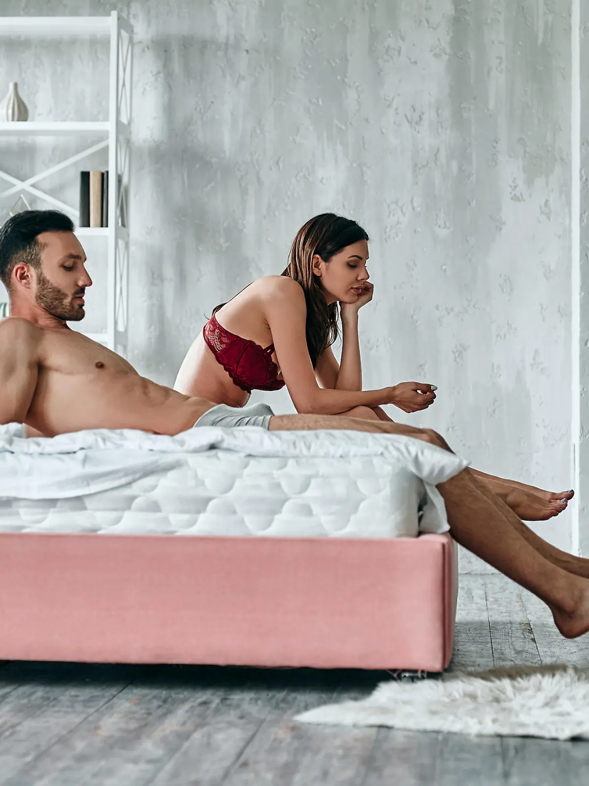 The man and woman sitting on the bed