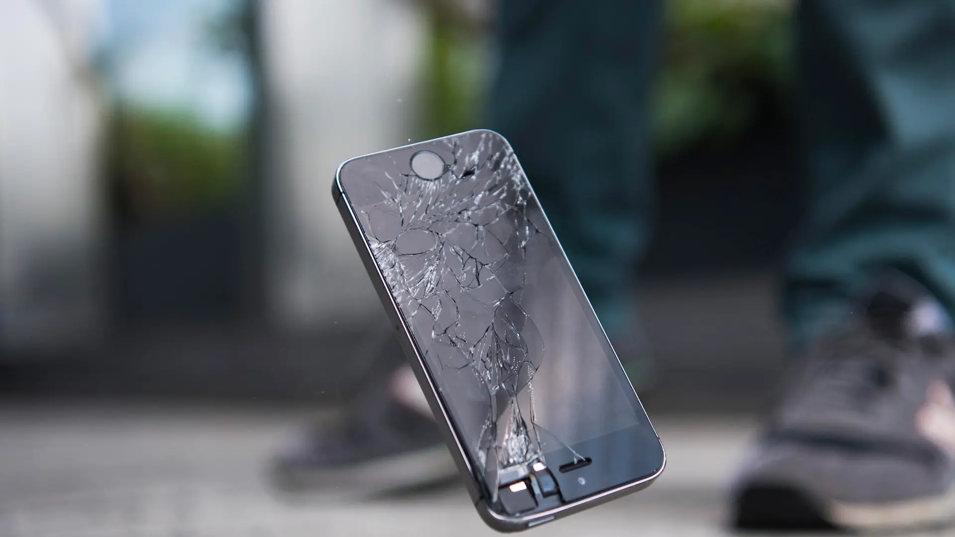 28.05.2018, Berlin: Ein Mann laesst ein Smartphone auf den Boden fallen. [ Rechtehinweis: picture alliance / dpa Themendienst ]