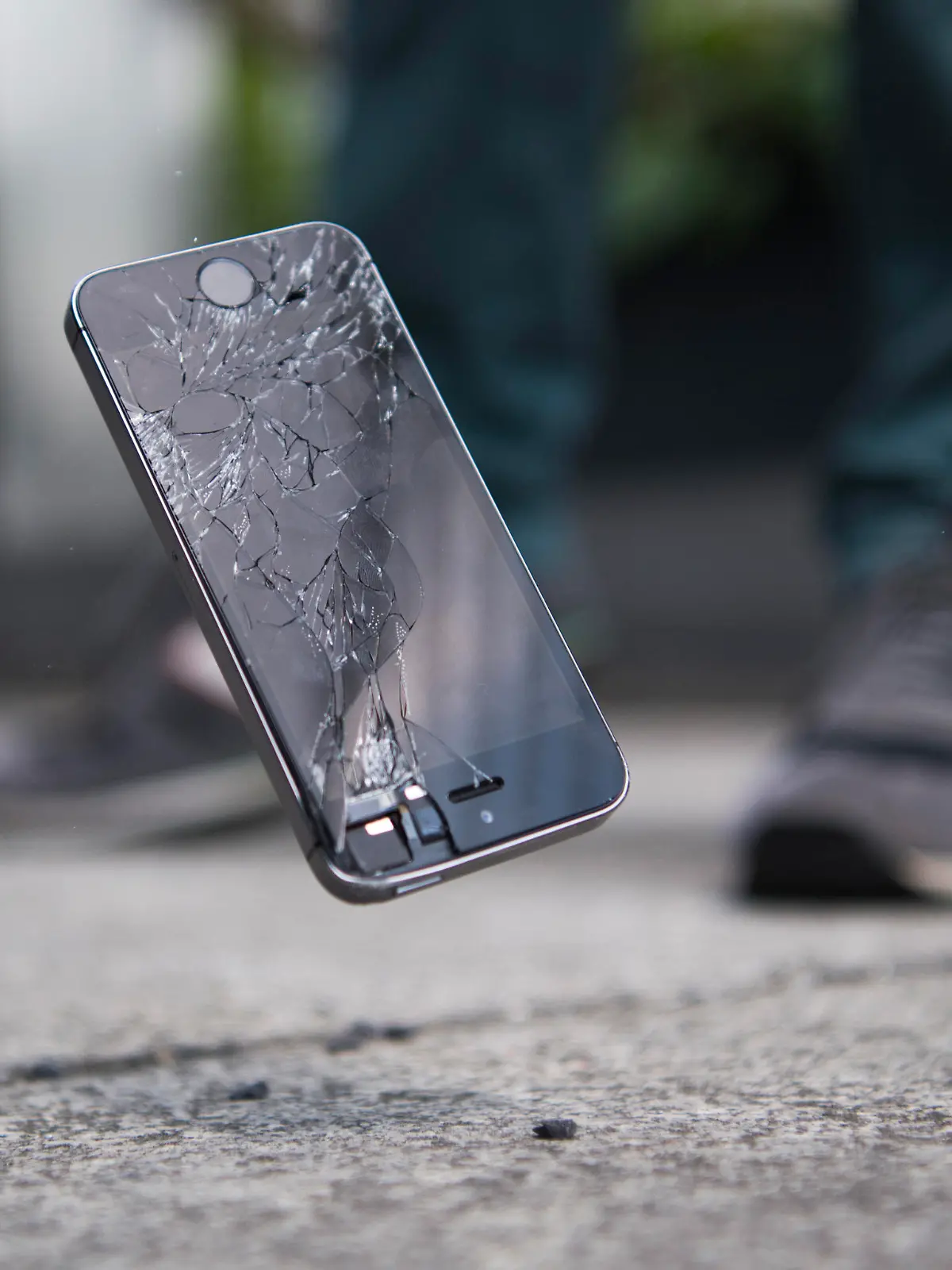 28.05.2018, Berlin: Ein Mann laesst ein Smartphone auf den Boden fallen. [ Rechtehinweis: picture alliance / dpa Themendienst ]