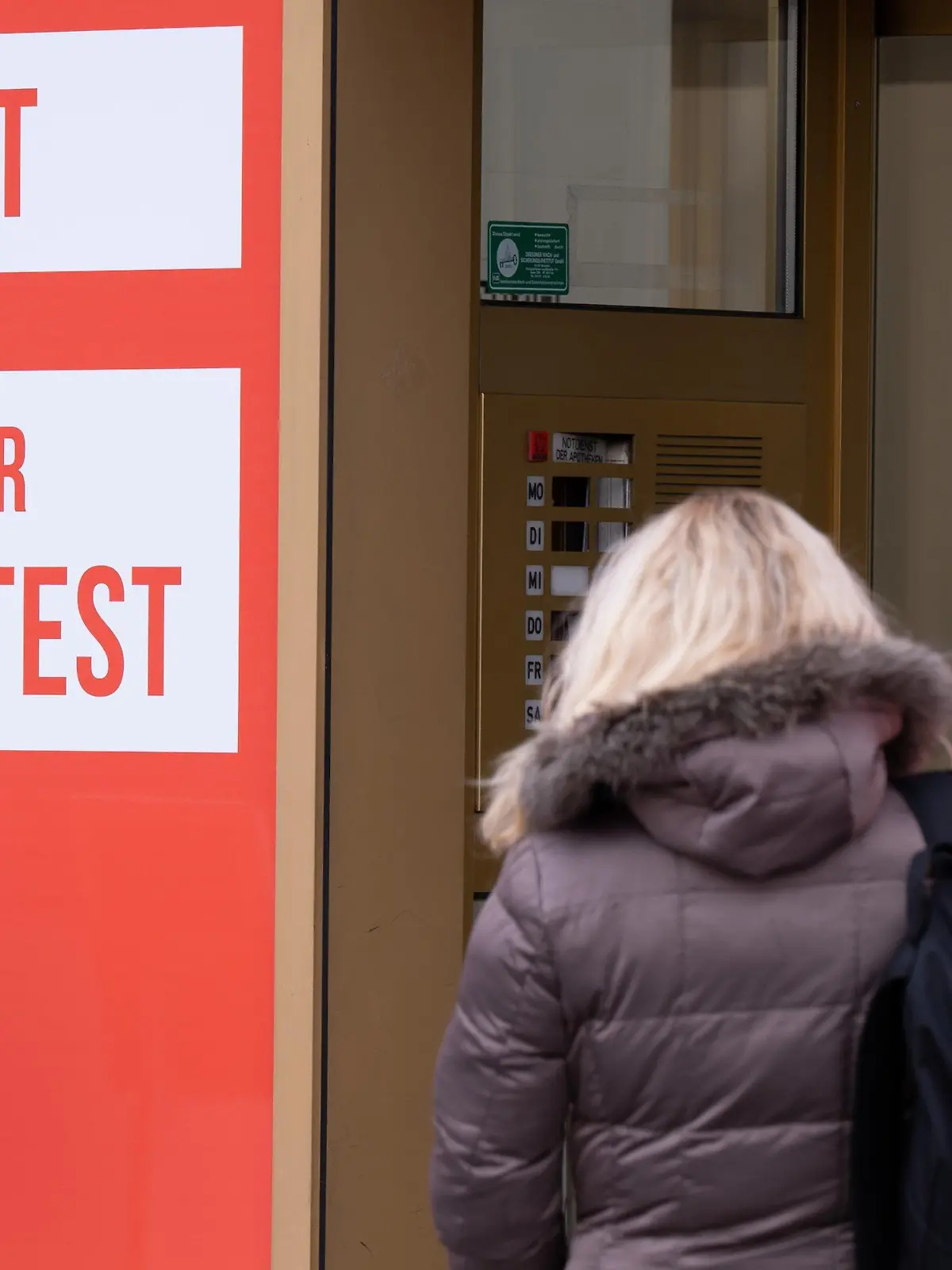 01.02.2022, Sachsen, Dresden: Eine Frau steht in der Dresdner Innenstadt vor einem Corona-Testzentrum. Foto: Sebastian Kahnert/dpa-Zentralbild/dpa +++ dpa-Bildfunk +++