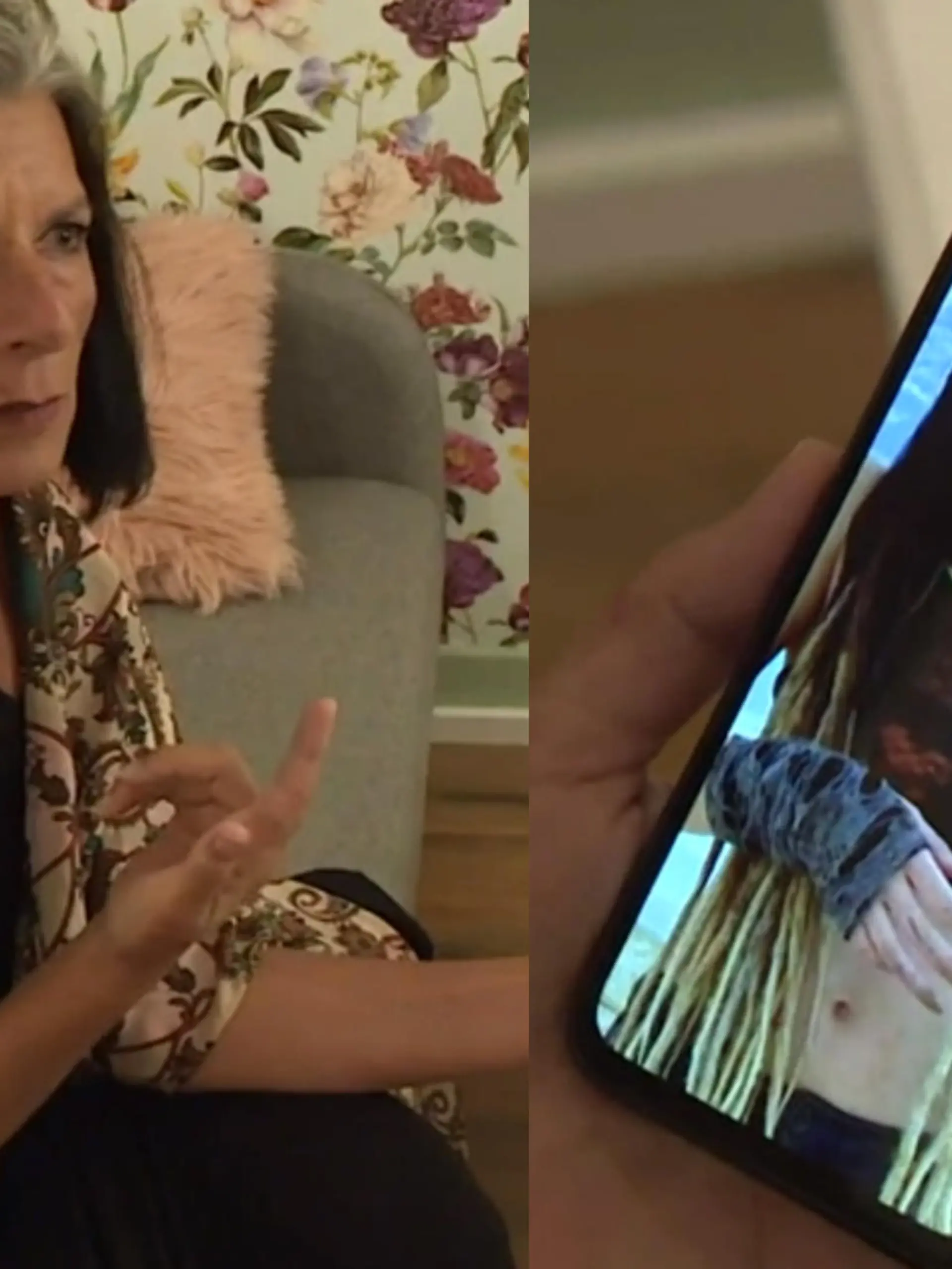 Eine Frau sitzt auf der Couch und hält ein Smartphone in der Hand.