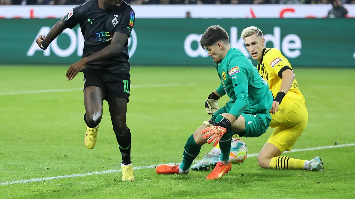 MOENCHENGLADBACH, GERMANY - NOVEMBER 11: Marcus Thuram of Borussia Monchengladbach has a shot saved by Gregor Kobel and Nico Schlotterbeck of Borussia Dortmund during the Bundesliga match between Borussia Mönchengladbach and Borussia Dortmund at Borussia-Park on November 11, 2022 in Moenchengladbach, Germany. (Photo by Christof Koepsel/Getty Images)