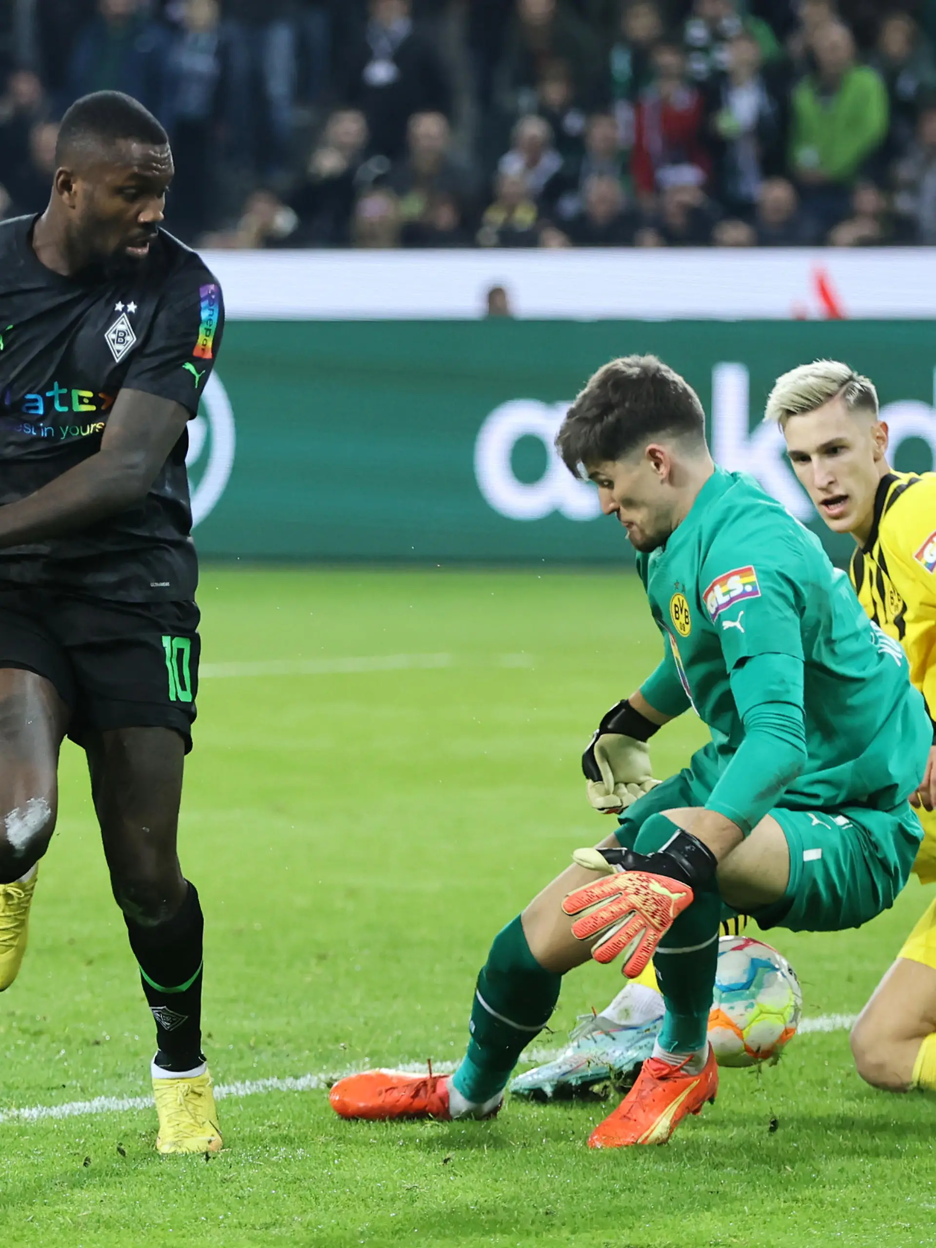 MOENCHENGLADBACH, GERMANY - NOVEMBER 11: Marcus Thuram of Borussia Monchengladbach has a shot saved by Gregor Kobel and Nico Schlotterbeck of Borussia Dortmund during the Bundesliga match between Borussia Mönchengladbach and Borussia Dortmund at Borussia-Park on November 11, 2022 in Moenchengladbach, Germany. (Photo by Christof Koepsel/Getty Images)