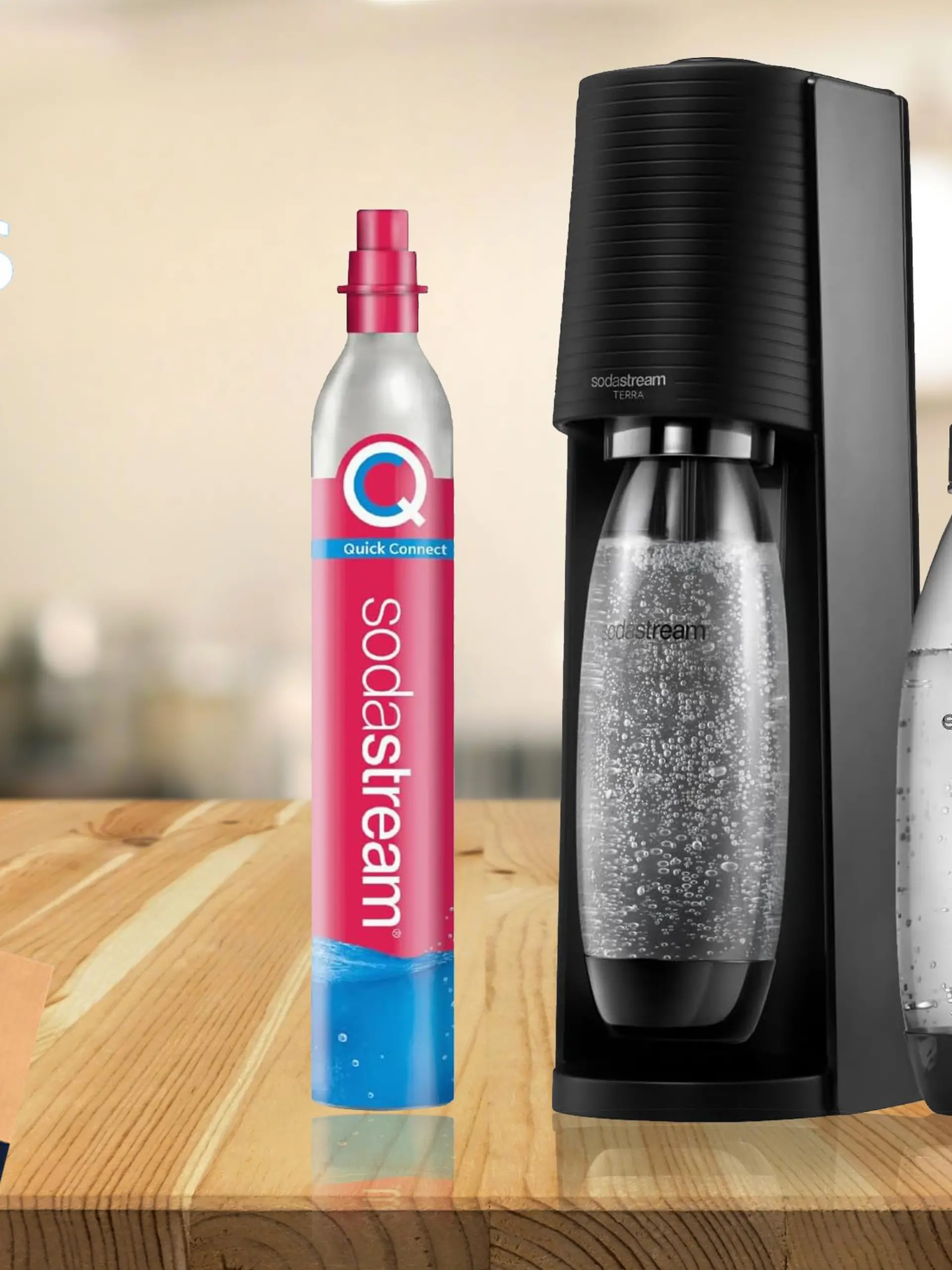 Der SodaStream Terra in Schwarz auf einem Holztisch mit zwei Kunststoffflaschen und einem Co2-Zylinder.
